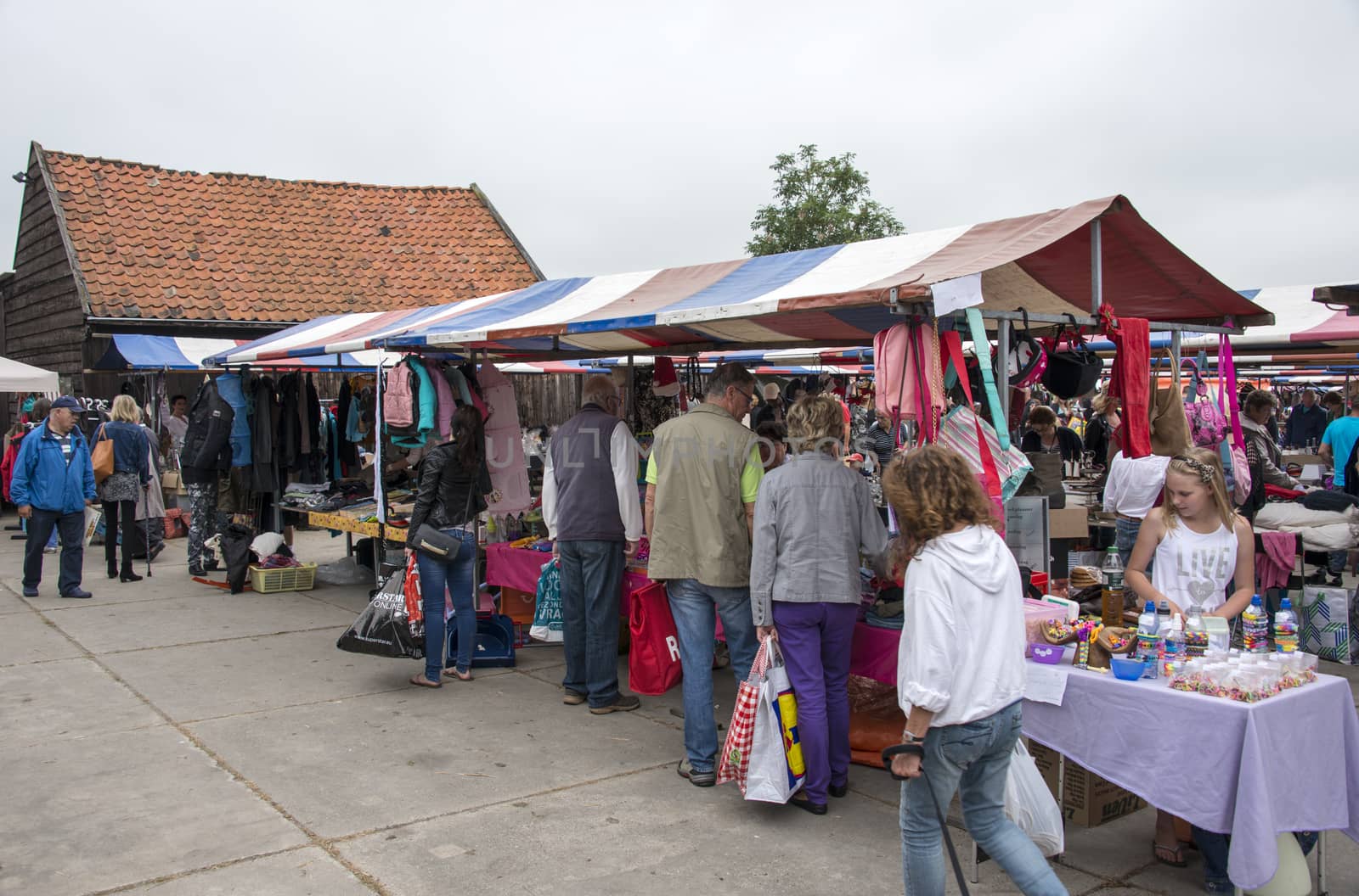 HELLEVOETSLUIS,NETHERLANDS-JULY 12, 2014: People shopping on the anual farmers market in Hellvoetsluis on July12,this market is only once a year and selling clothes and fresh food