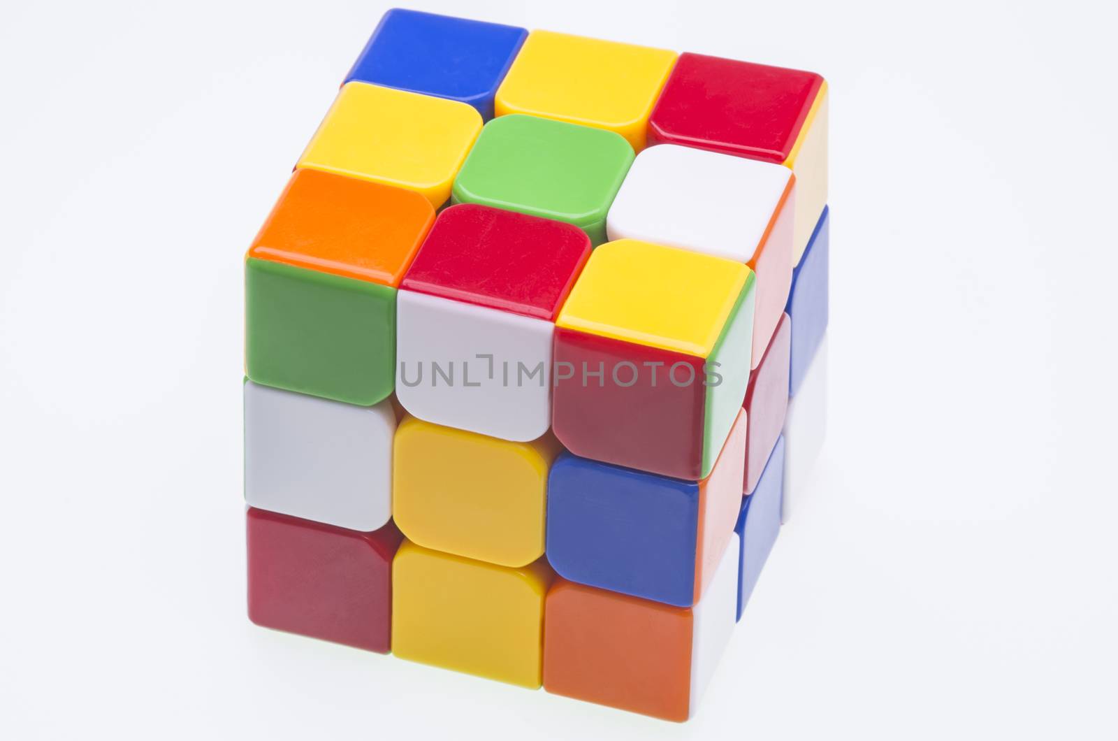 Close image of a scrambled Rubik's cube over white.