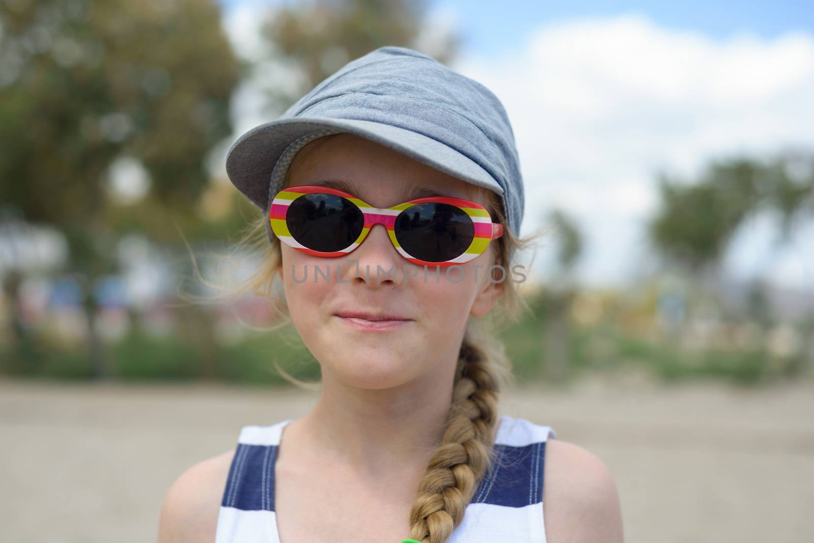 Cute little girl in denim hat and sunglasses