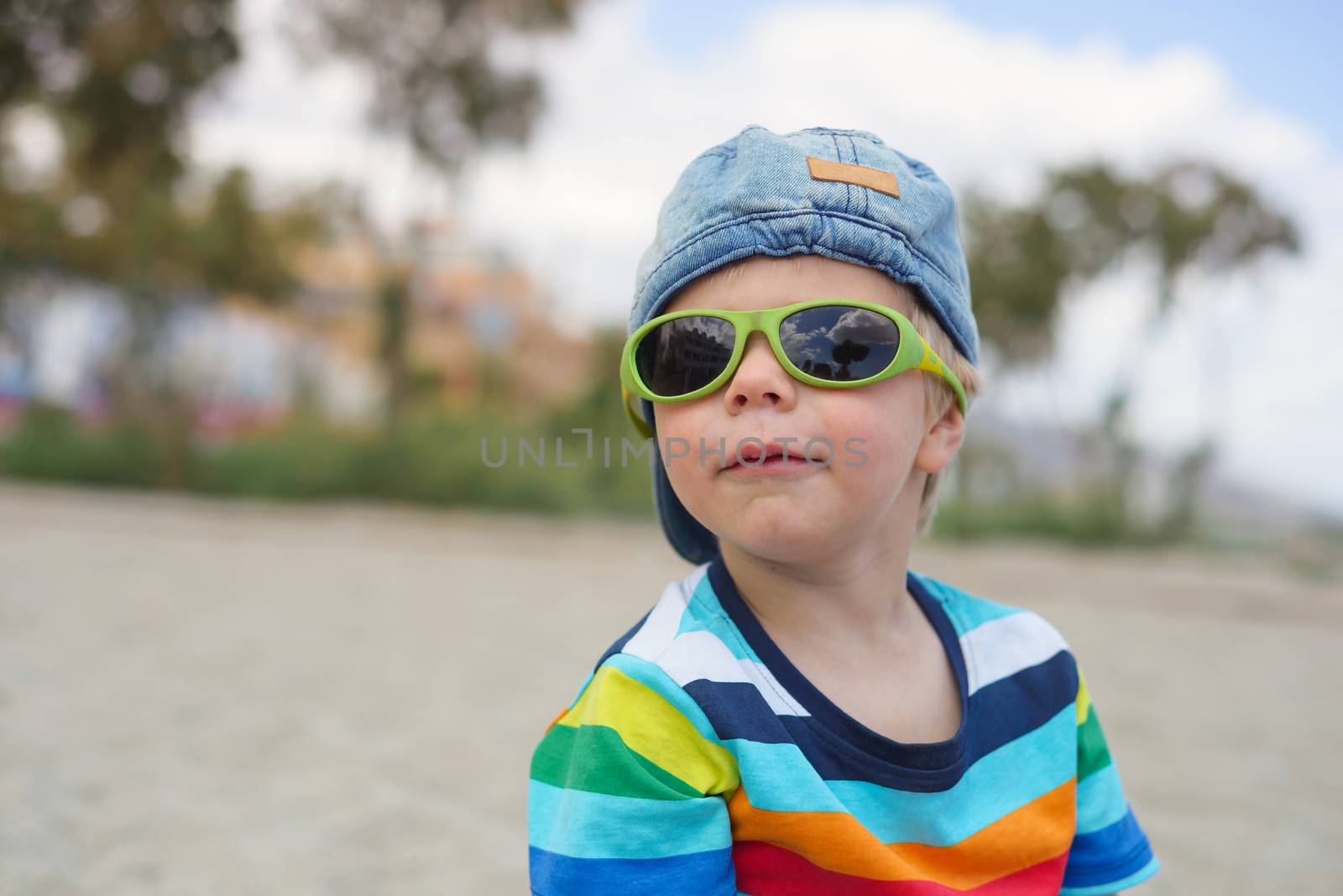 Cute little boy in denim hat and sunglasses