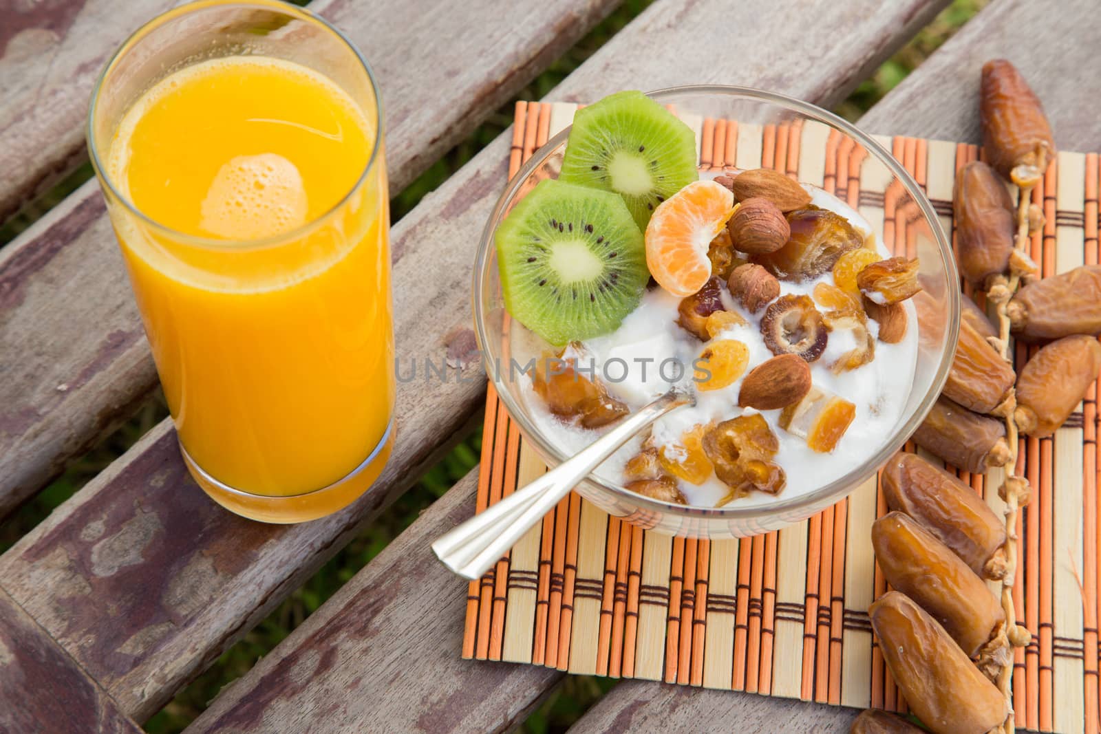 Healthy breakfast: a glass of fresh orange juice and a dish of yogourt with fruits