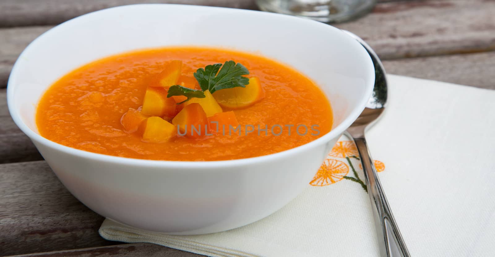 A plate of carrot soup with fresh pasley by tolikoff_photography