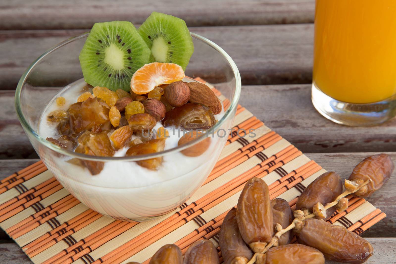 Healthy breakfast - natural yogurt with dried fruits and a glass of orange juice