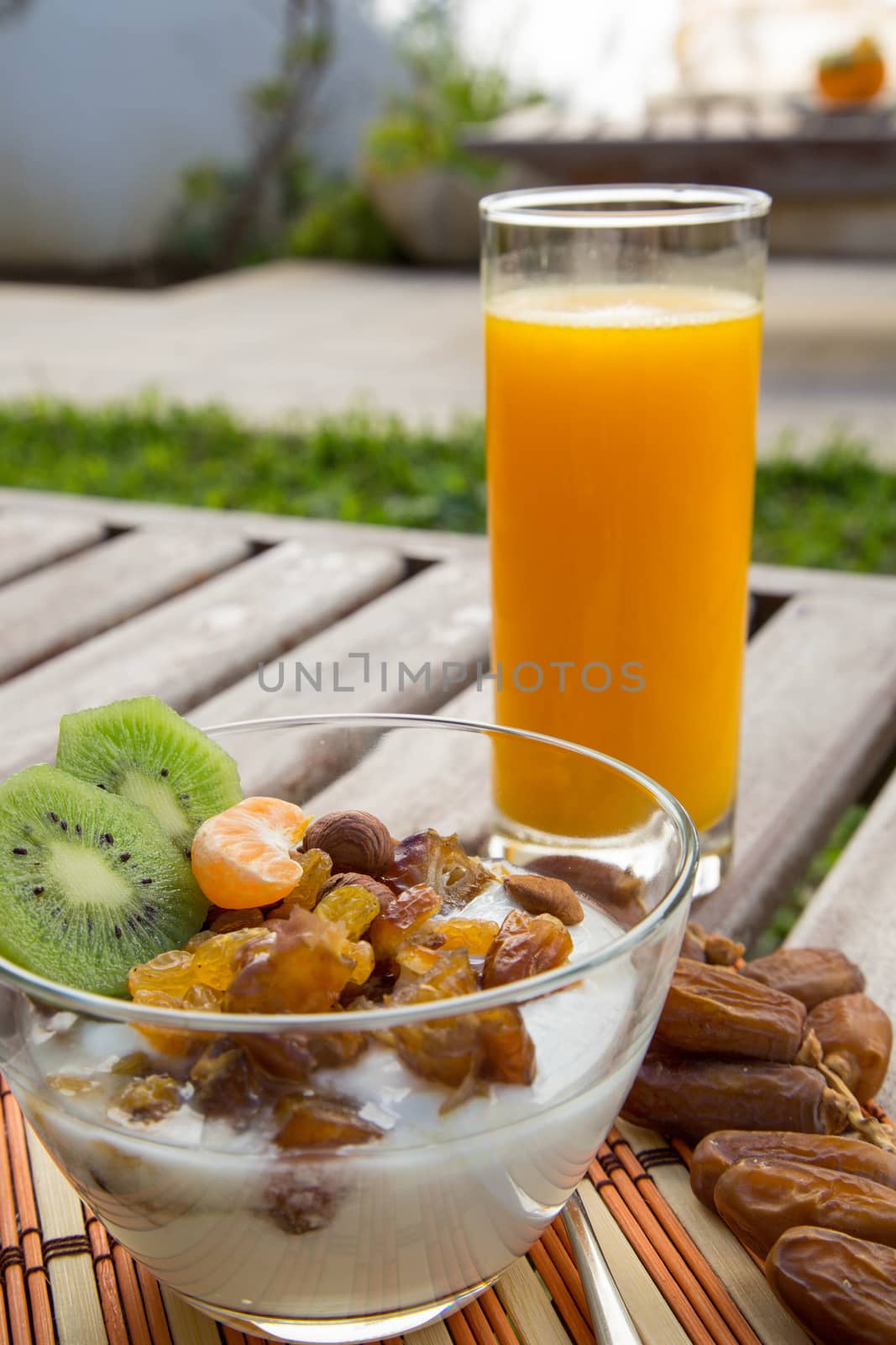 Healthy breakfast - natural yogurt with dried fruits and a glass of orange juice