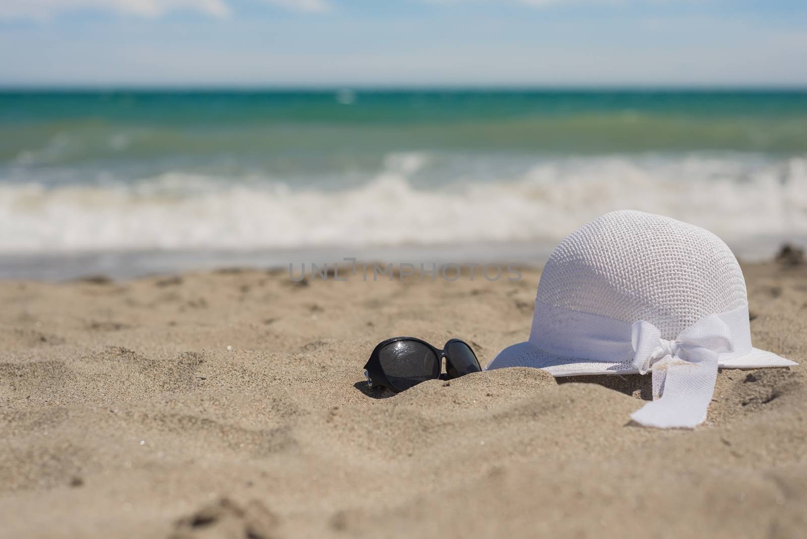 White wicker hat and sunglasses on the beach