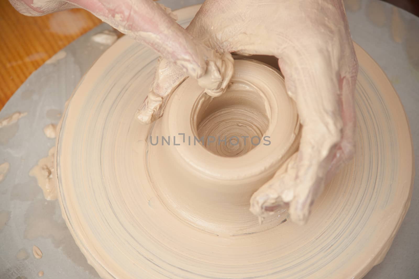 Hands of a potter, creating an earthen jar on the circle