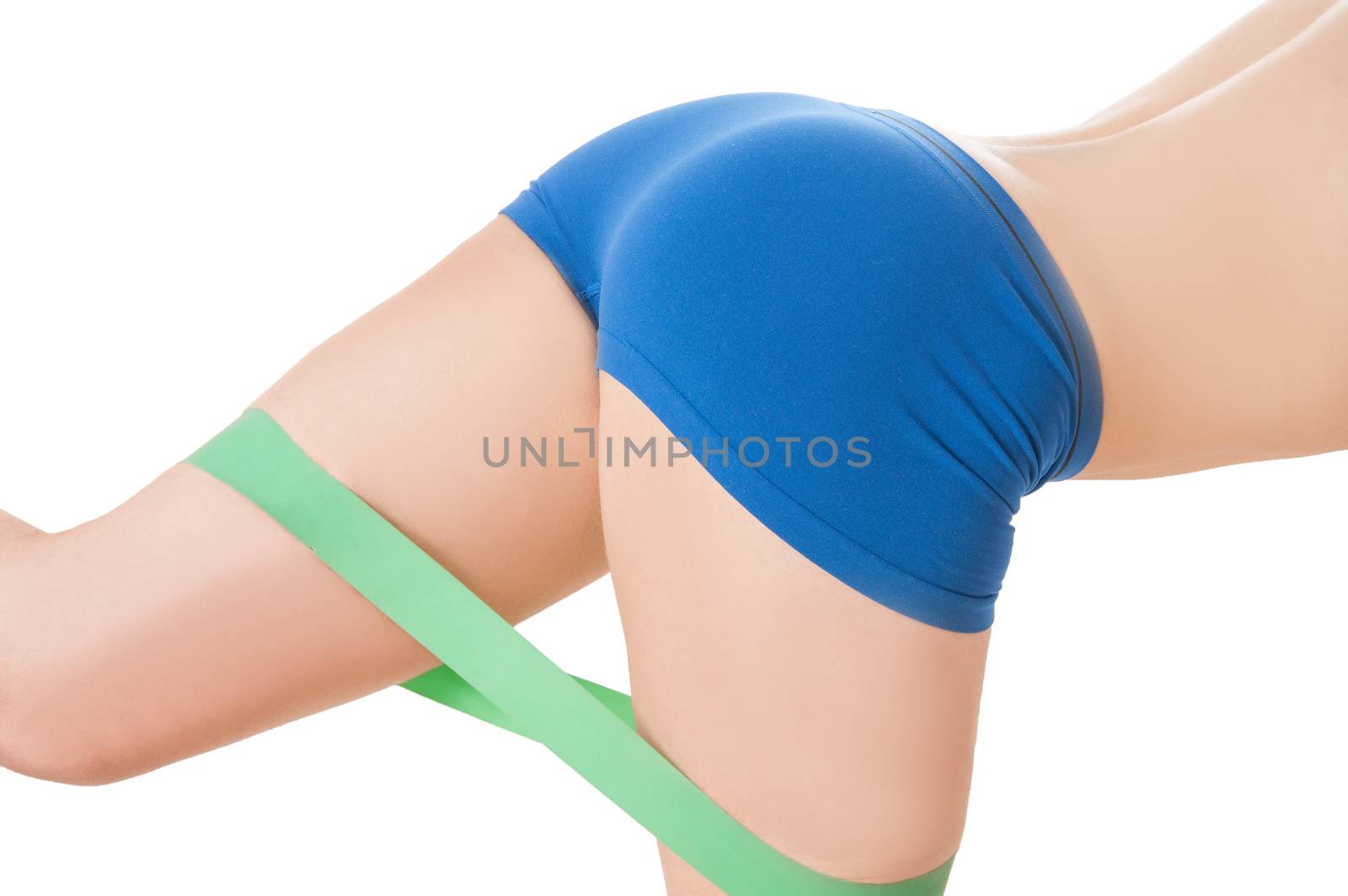 Fittness woman exercising with greenelastic rubber band wearing blue workout shorts