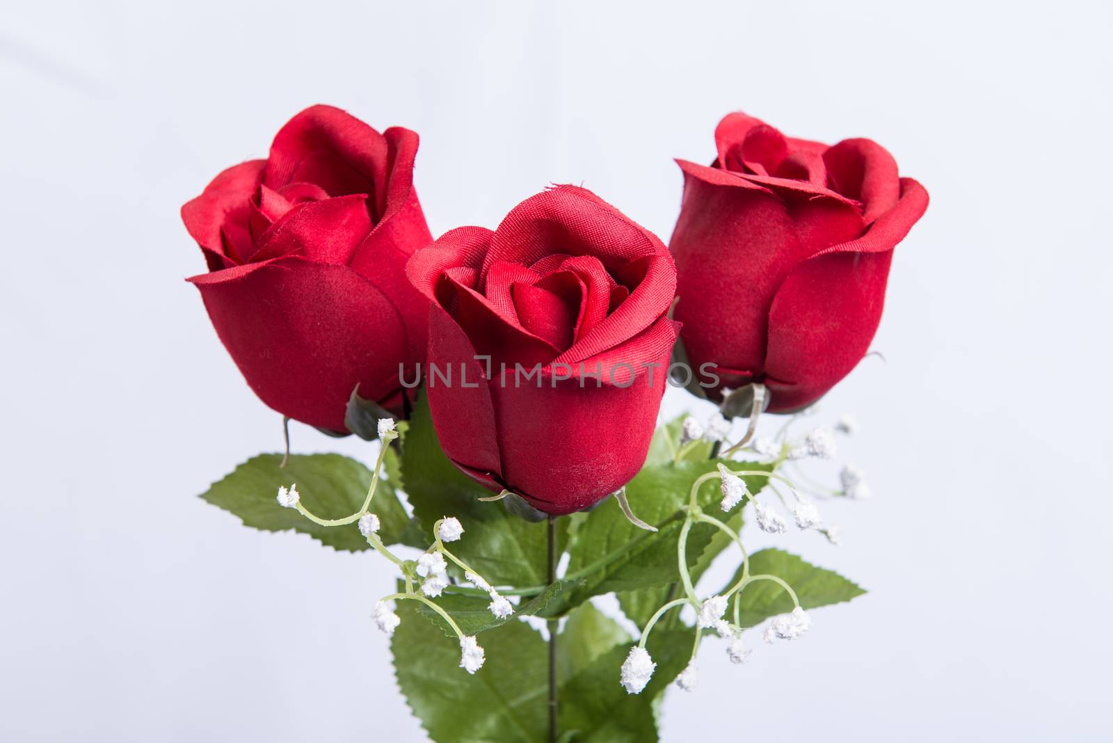 Fake fabric red rose and green stem isolated over white background