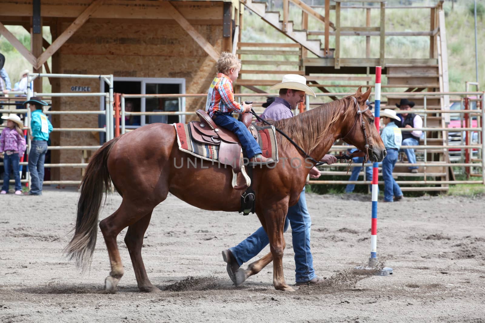 MERRITT, B.c. CANADA - June 14:  Young cowboy and his dad in stake race event at the Little Britches Rodeo June 14, 2014 in Merritt British Columbia, Canada