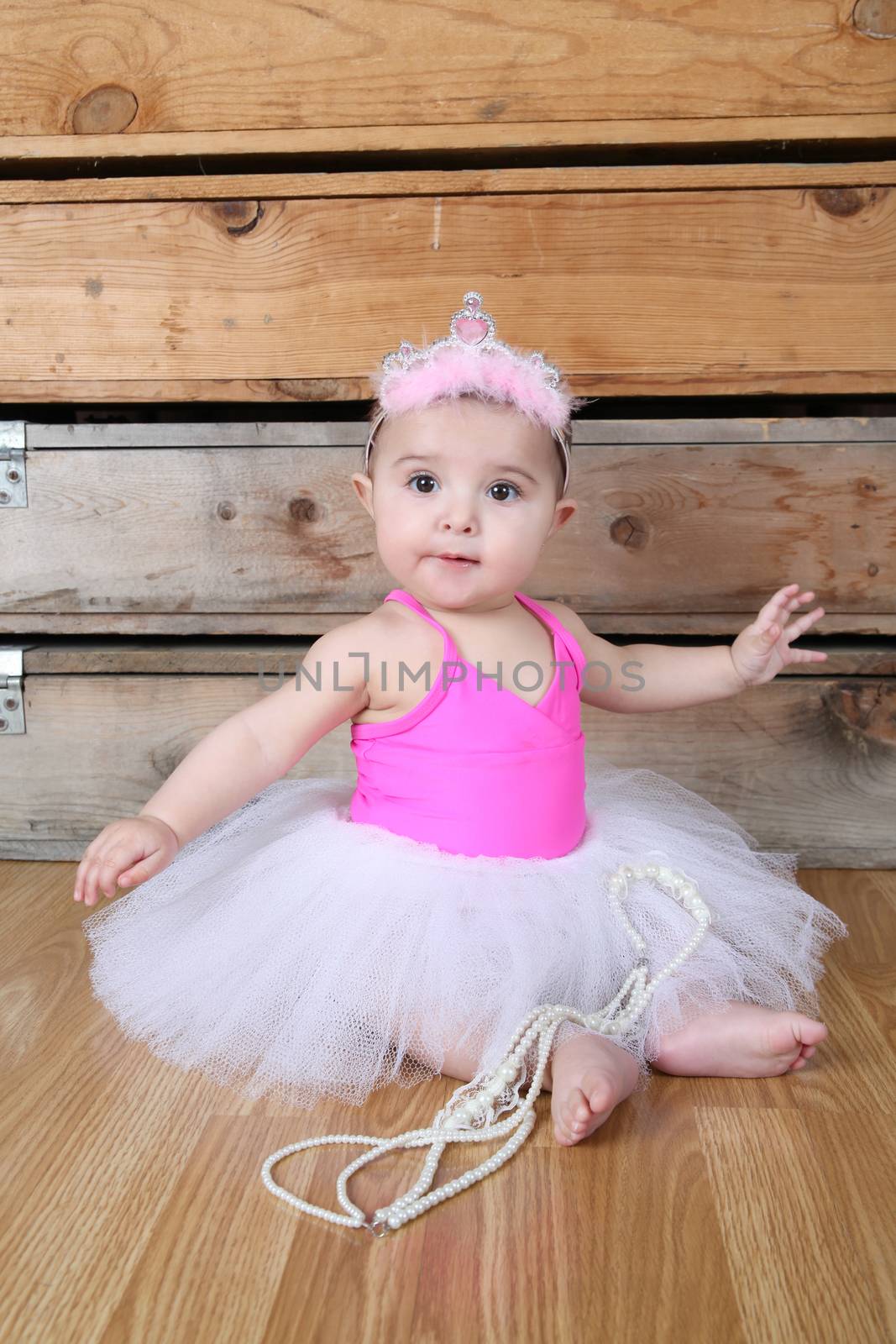 Baby ballerina wearing a white tutu and pink bodysuit 