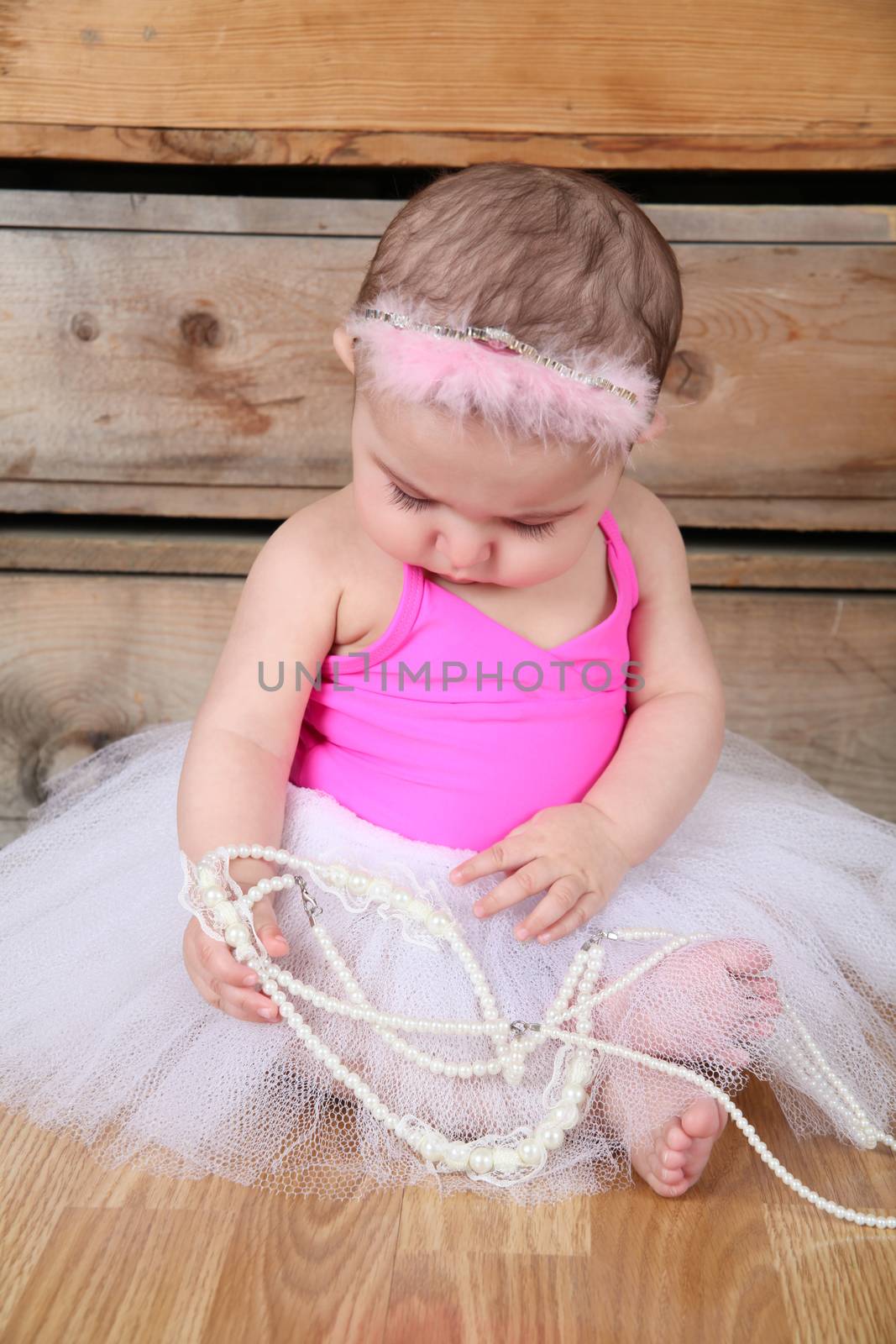 Baby ballerina wearing a white tutu and pink bodysuit 