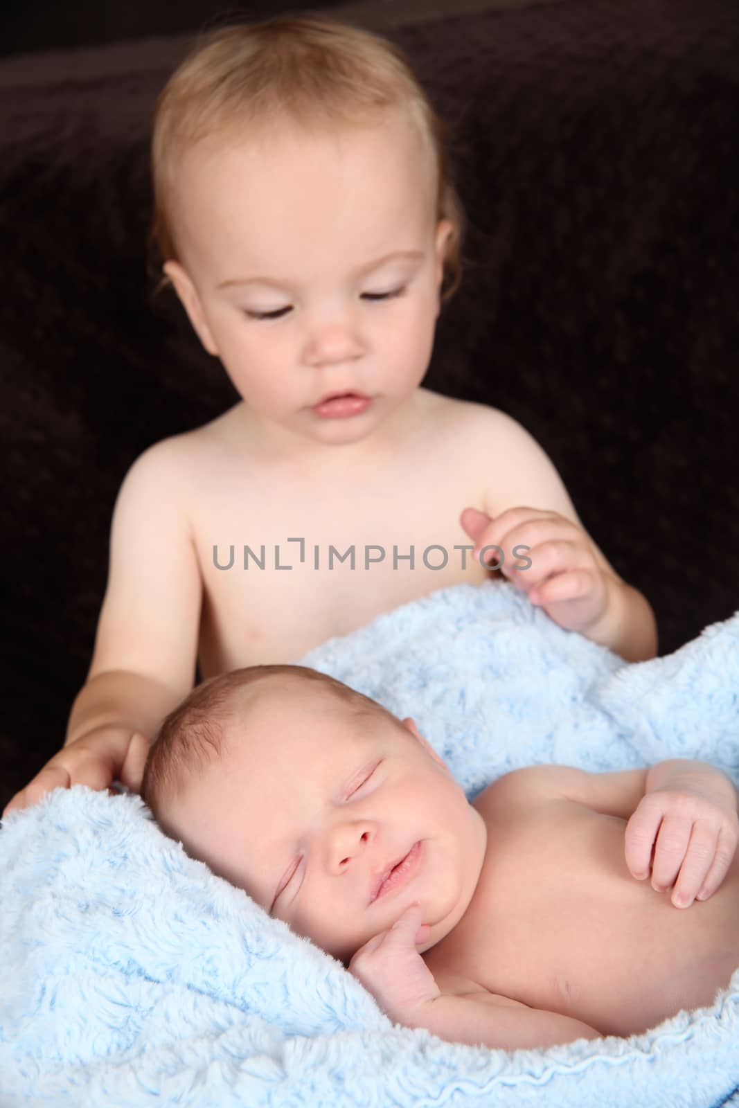 Toddler boy with his newborn baby brother