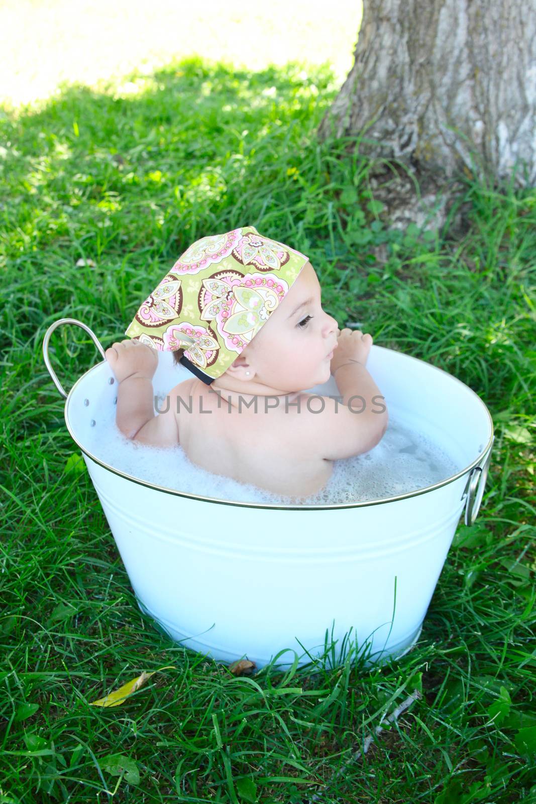 Beautiful baby girl having a bath outdoors