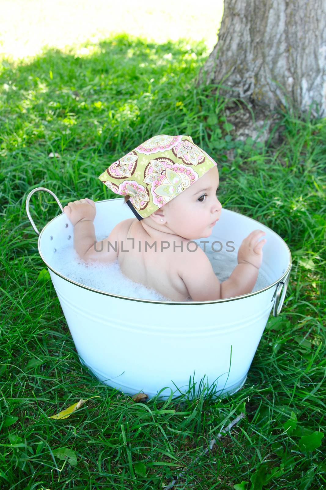 Beautiful baby girl having a bath outdoors