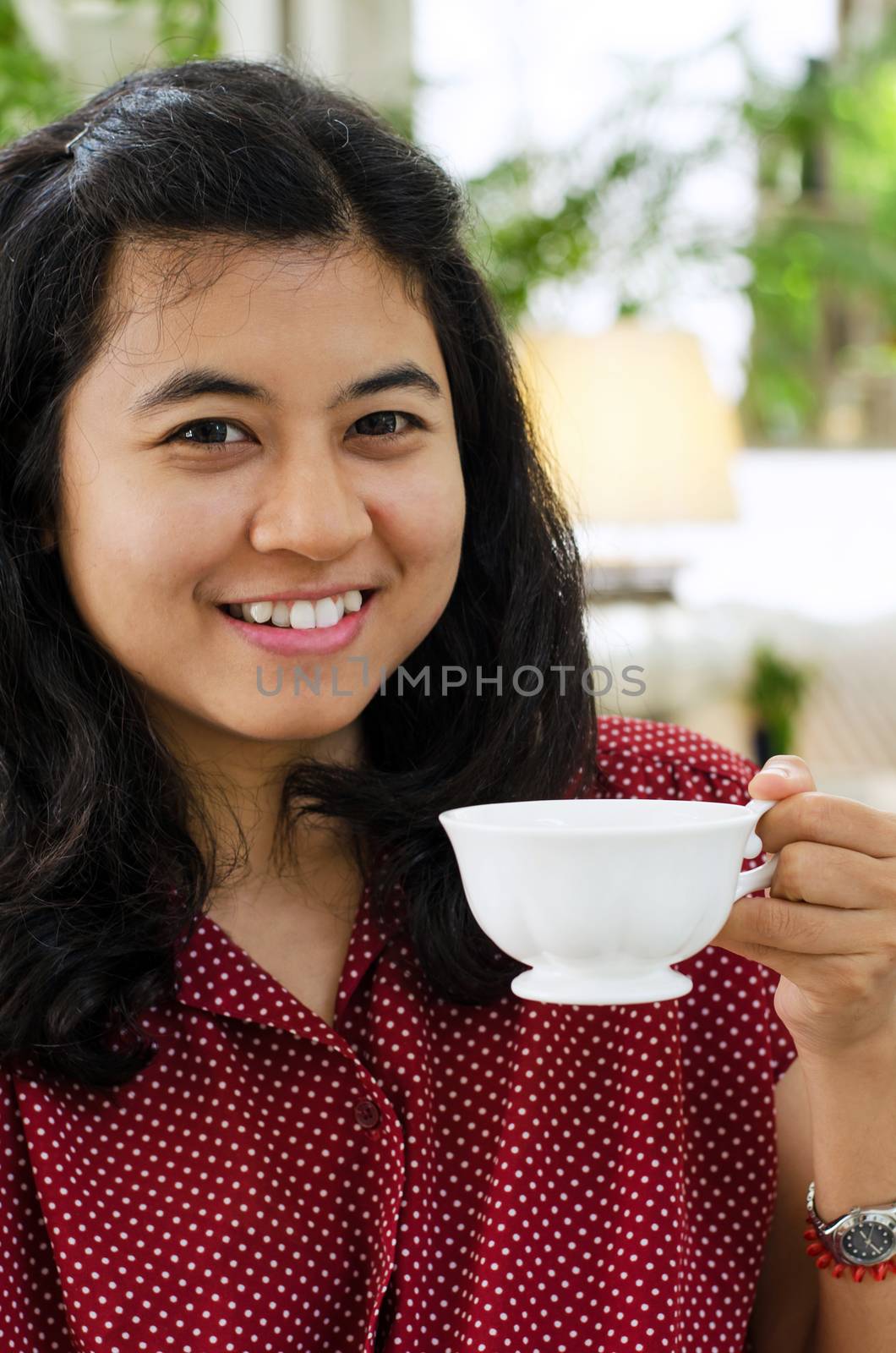 Young woman at home sipping tea from a cup 