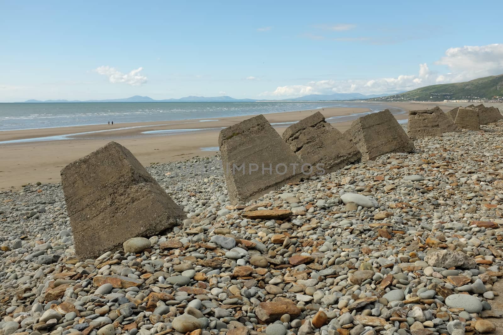 Pebbles and concrete  bollards make up the sea defences on the beautifull Fairbourne beach, Gwynedd, Wales, UK