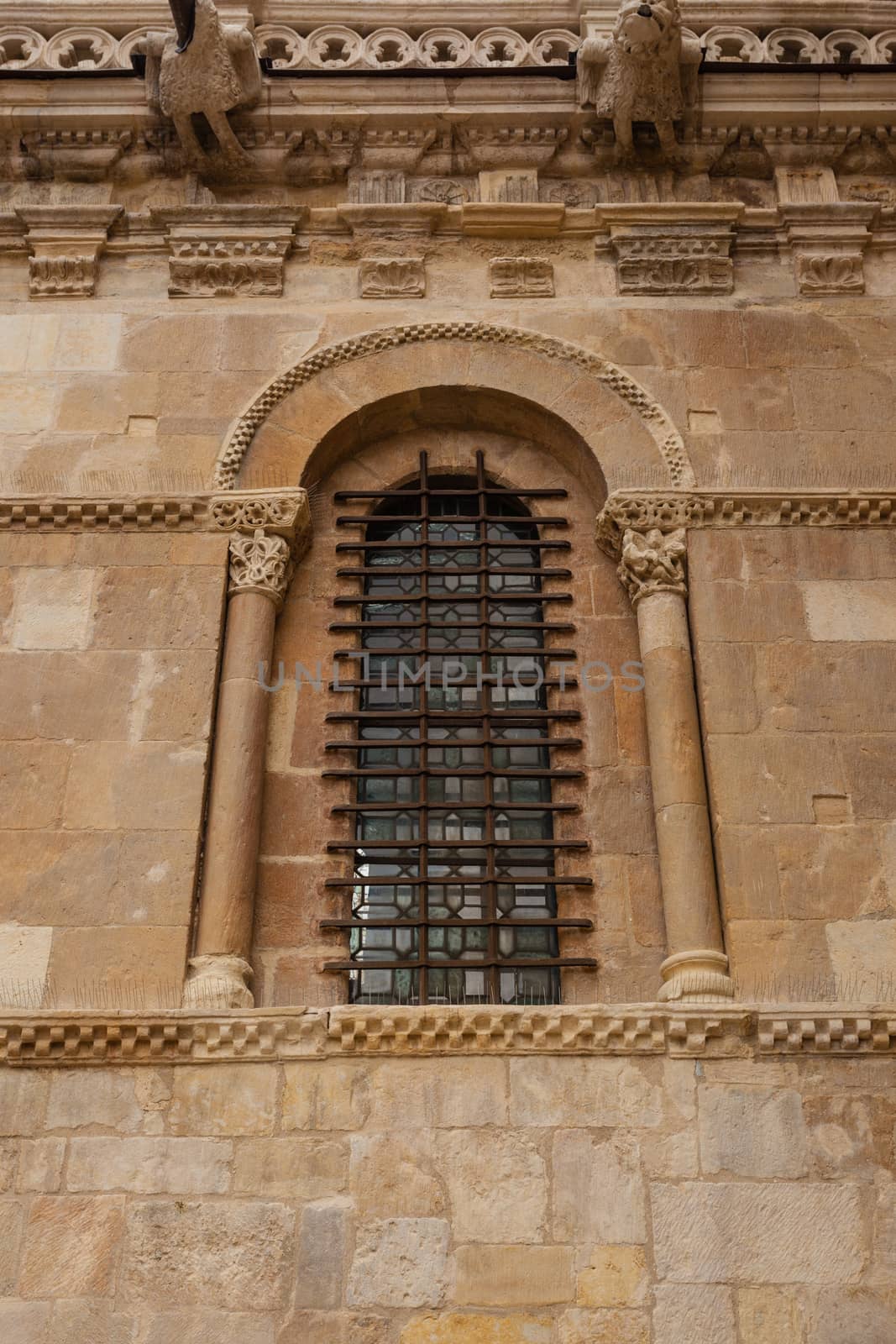 Excellent piece of romanesque art window with fine forged protection in the side wall of the San Isidoro collegiate church in Leon ,Spain