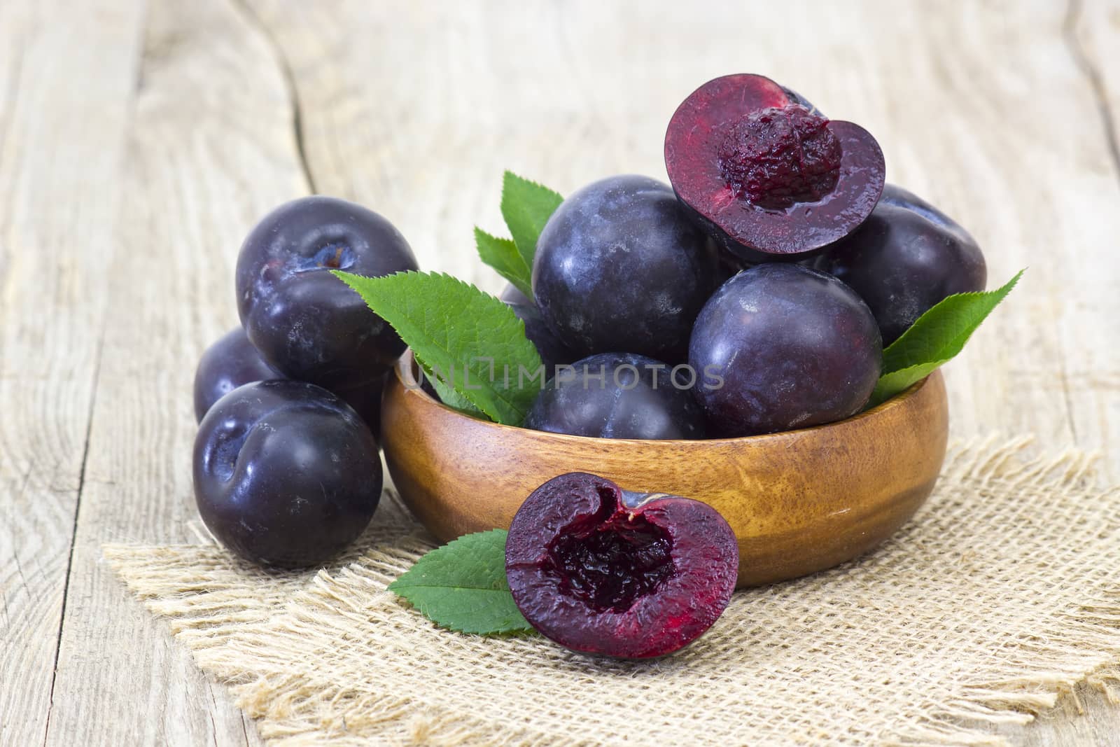 fresh plums in a bowl wooden background