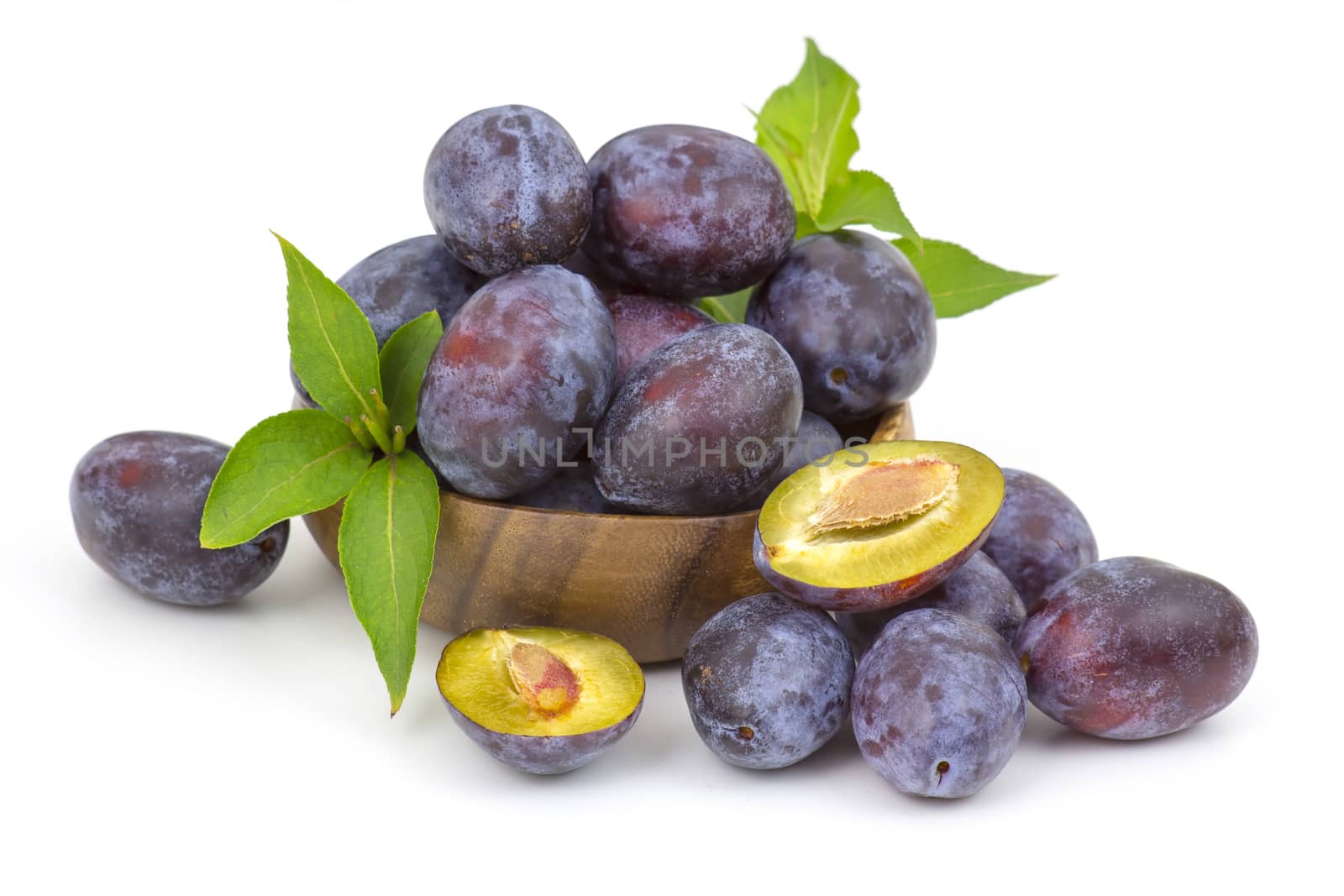 fresh plums in a bowl on white background