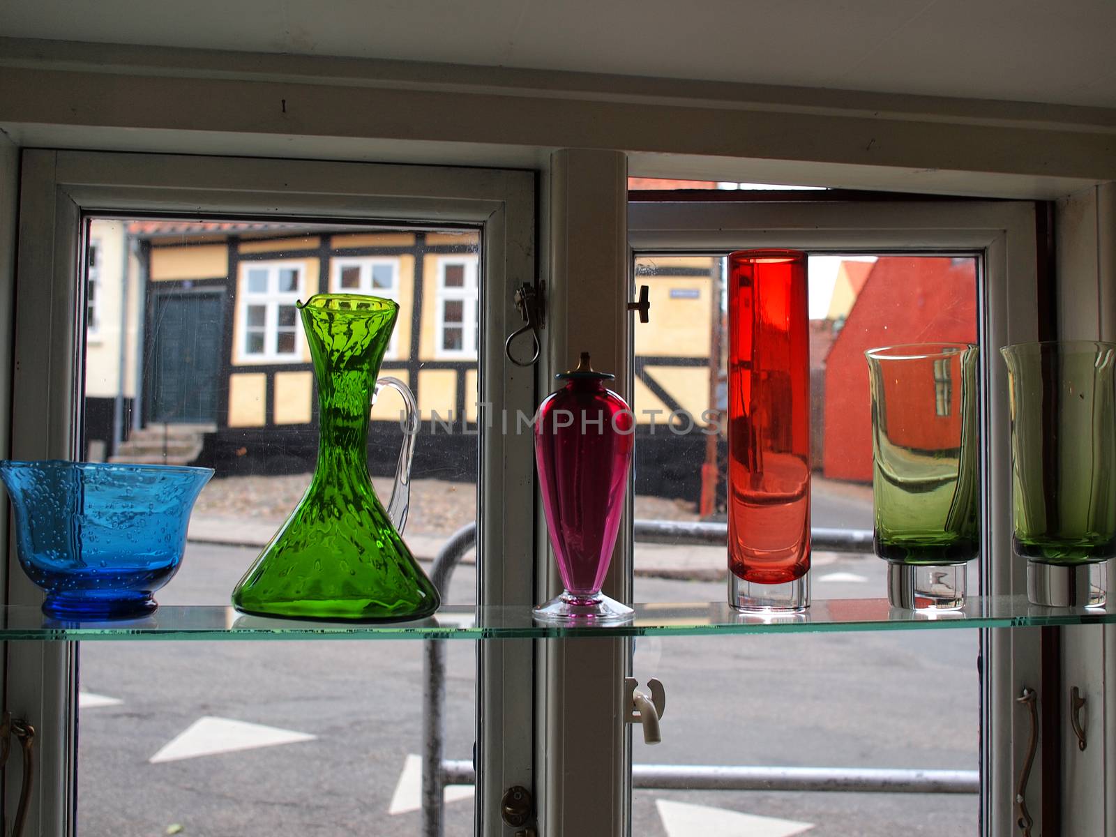 Beautiful decorative colorful glass carafes vase bottles in a window of a shop