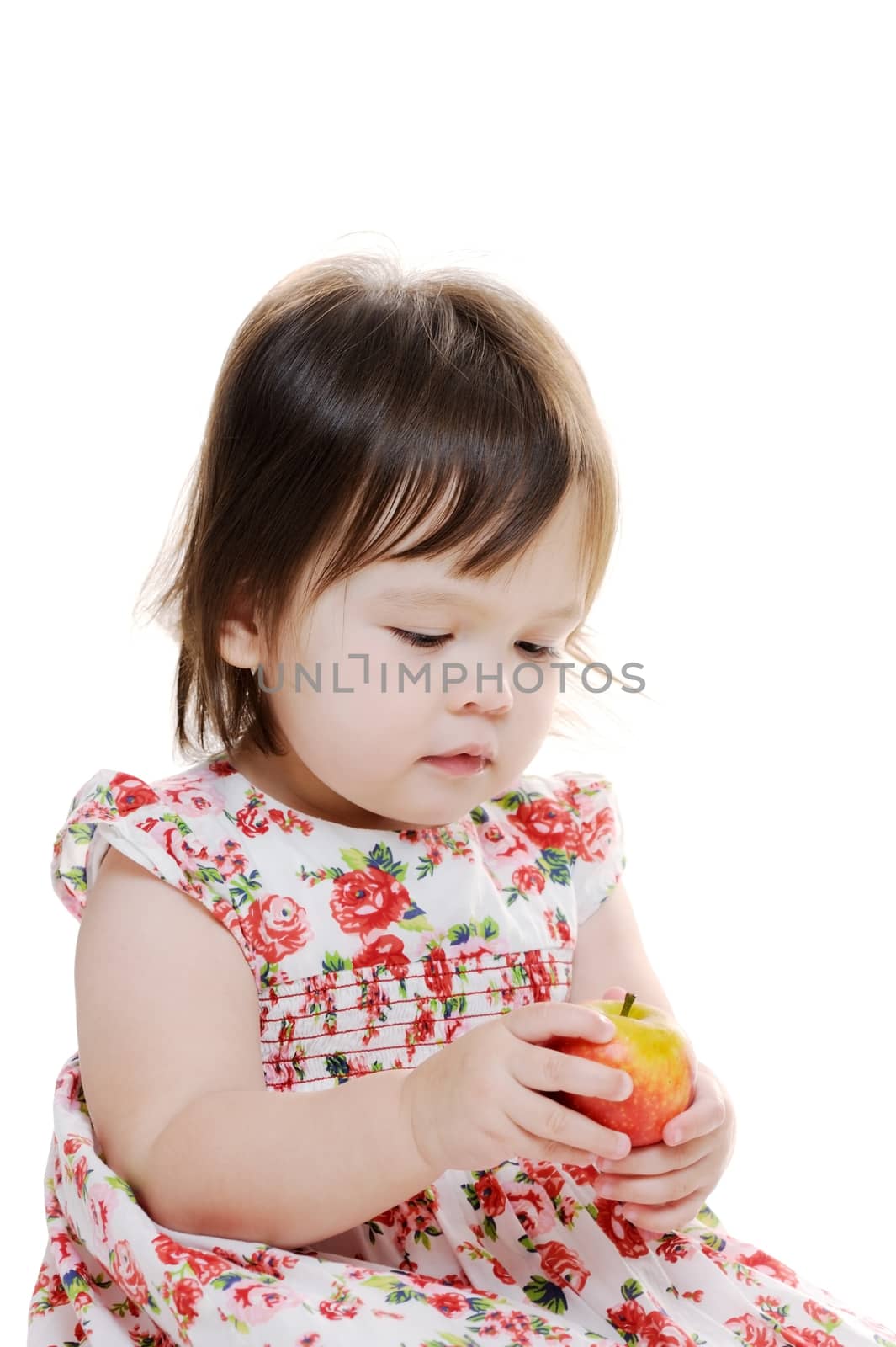 Infant girl holding her first apple