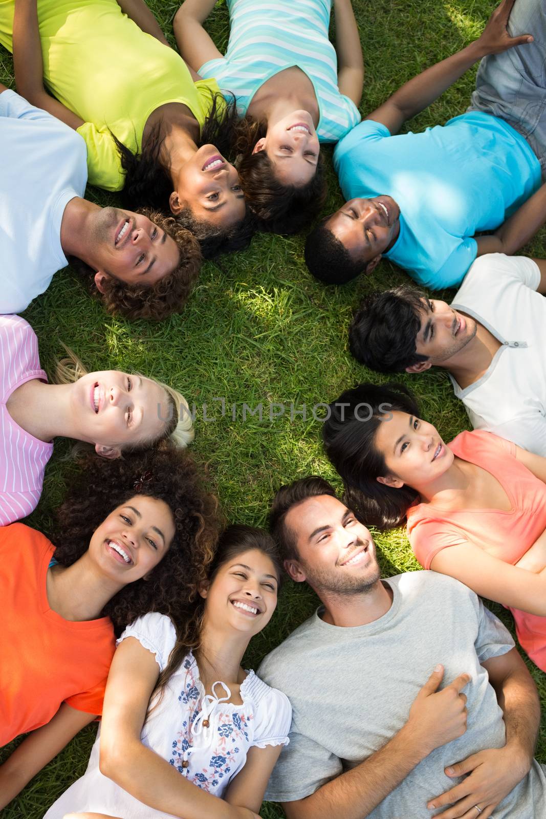 High angle view of a group of friends lying down in a circle at park 
