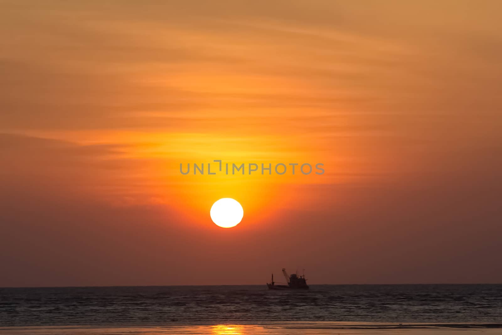 Sunset on the beach with fisherman boat over ther sea