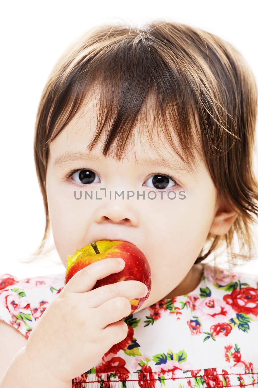Young girl taking bite from big red apple