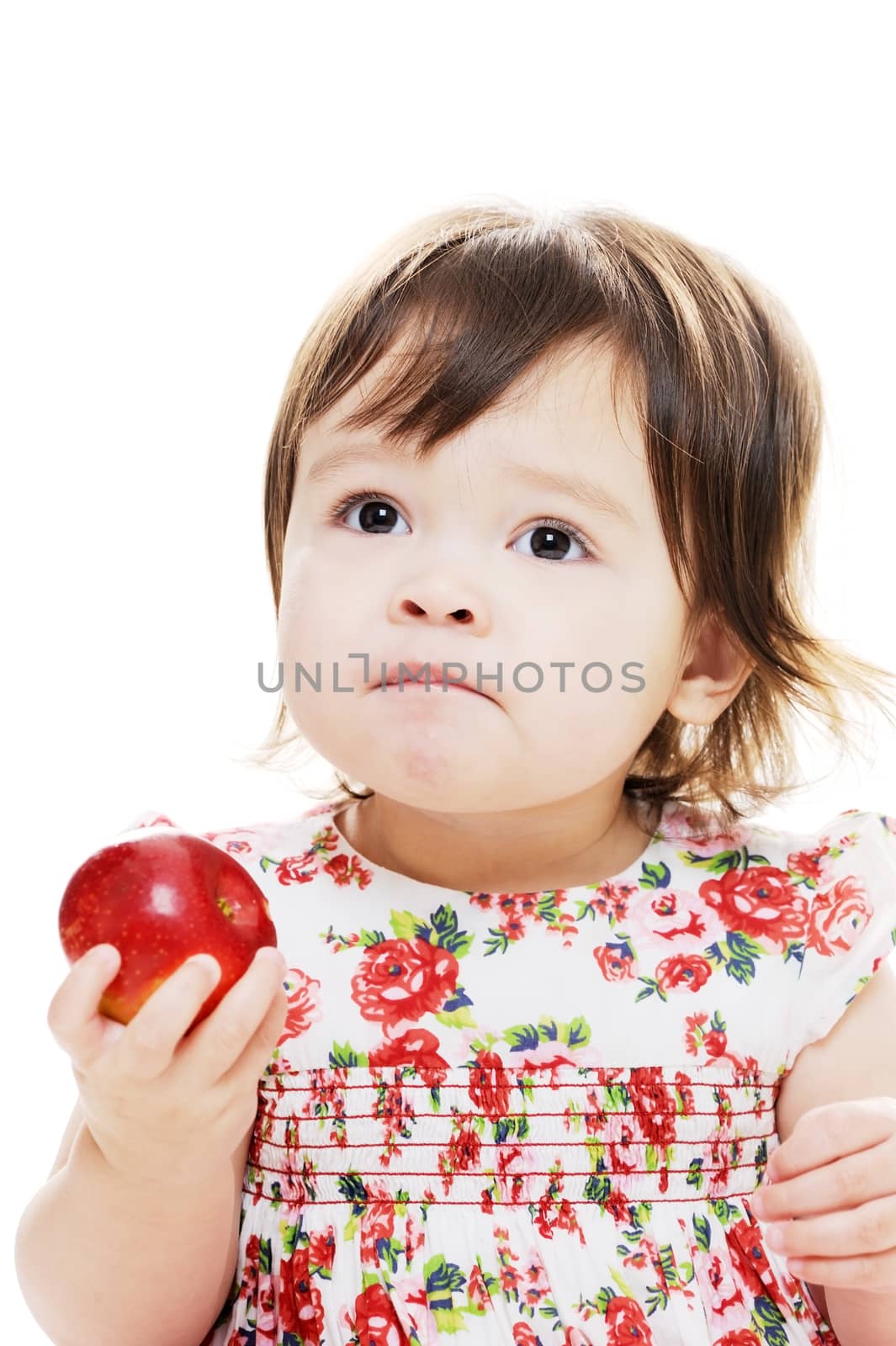 Baby girl tasting a red fresh red apple