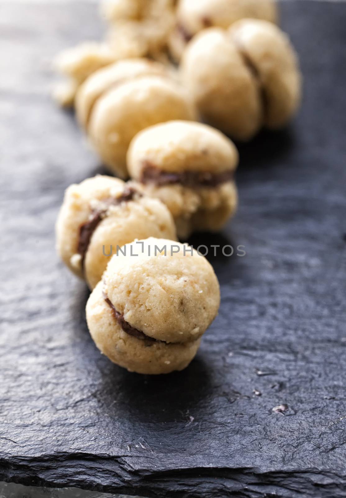 Biscuits "Baci di dama" in a row over black stone