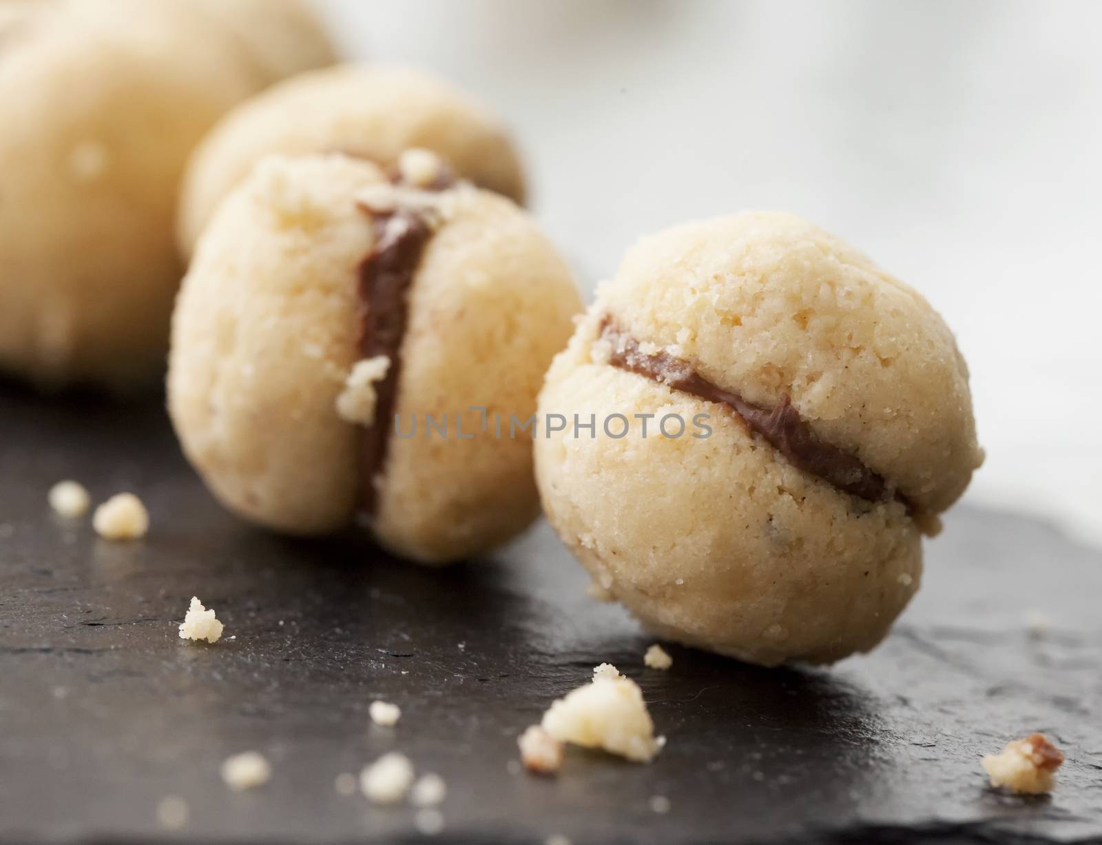 Biscuits "Baci di dama" in a row over black stone