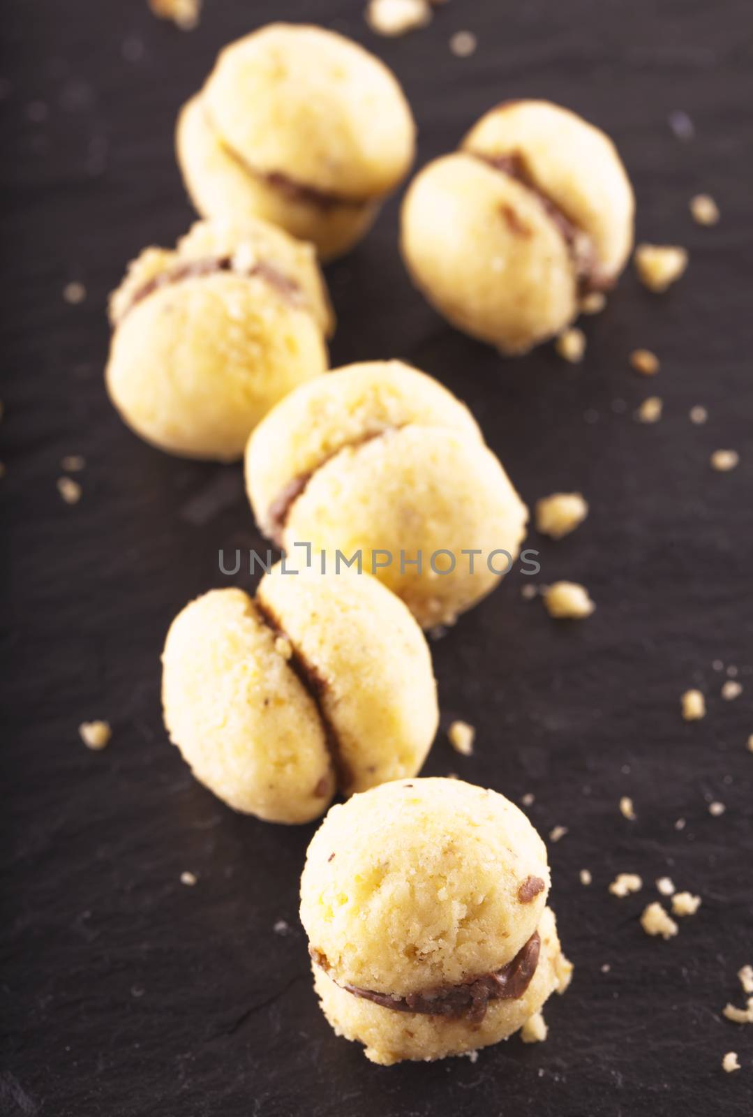 Biscuits "Baci di dama" in a row over black stone