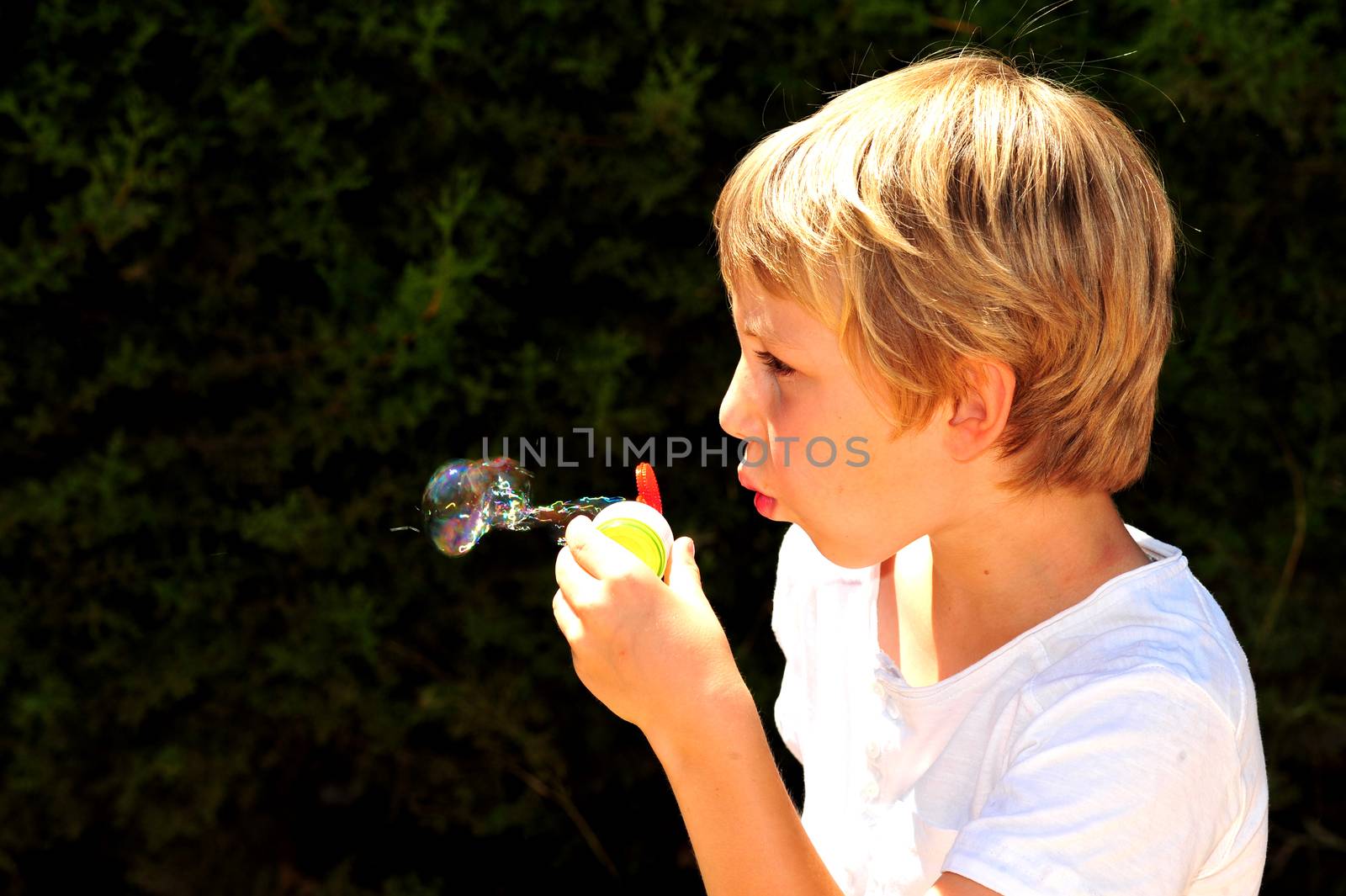 Young boy playing with bubbles in the garden