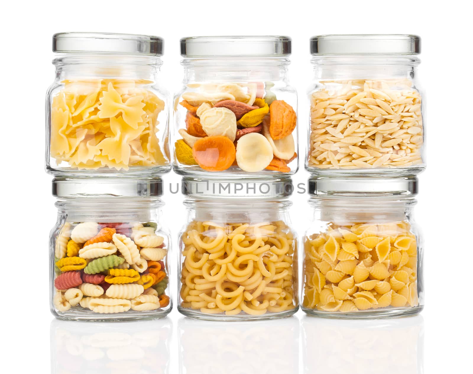 the various raw pasta in a glass jar,  isolated on white background