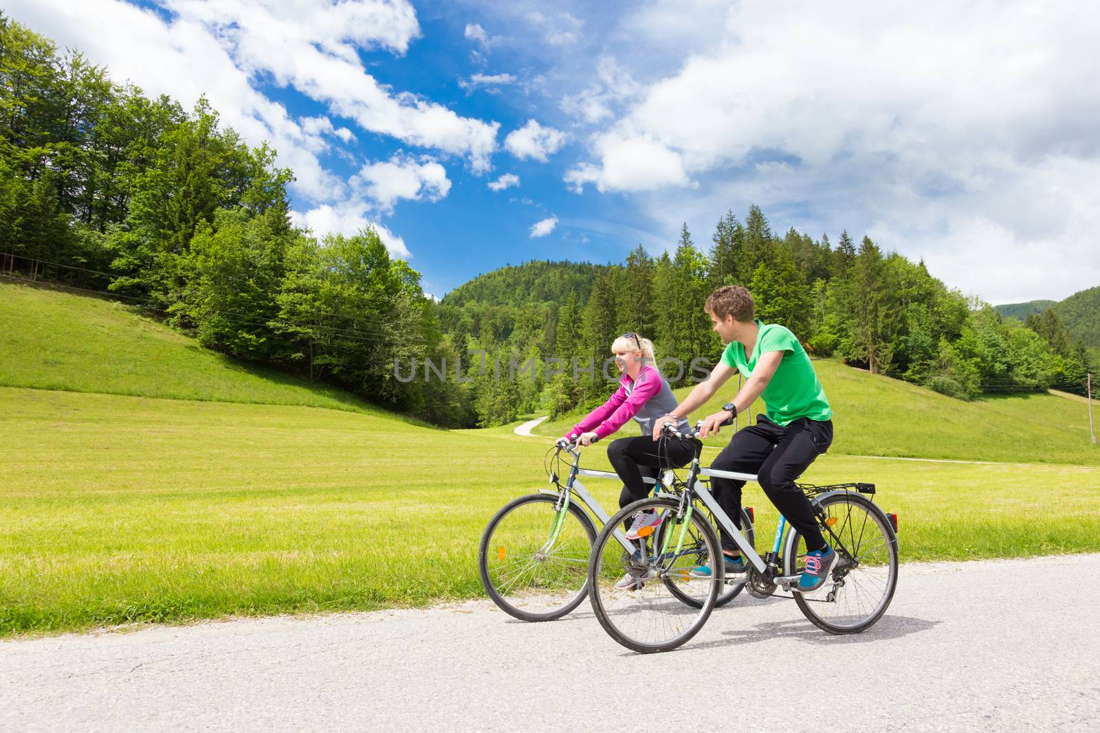 Young spoty active cople biking in nature. Active lifestyle. Activities and recreation outdoors.