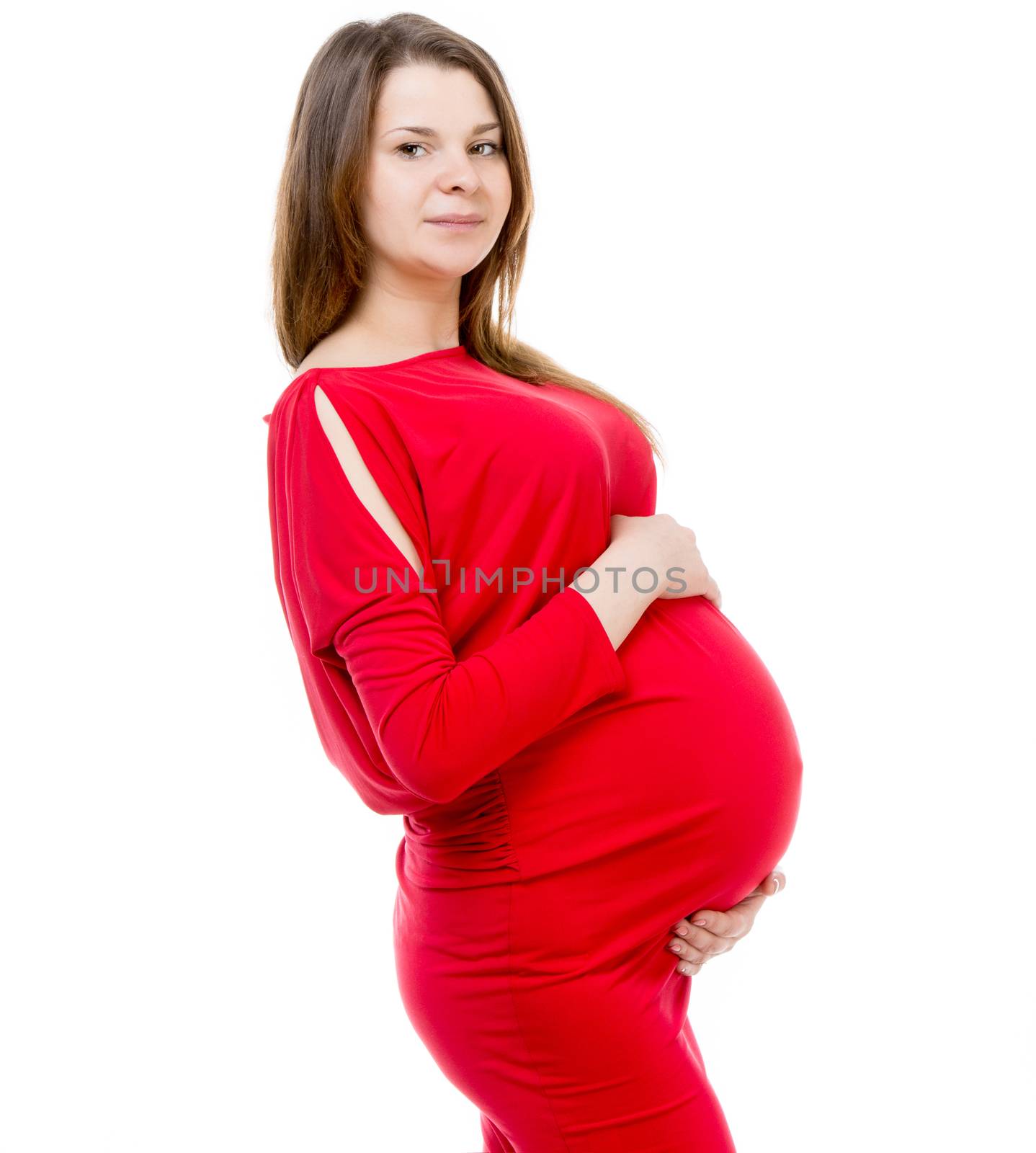 beautiful pregnant girl in a red dress hugging her belly on white background