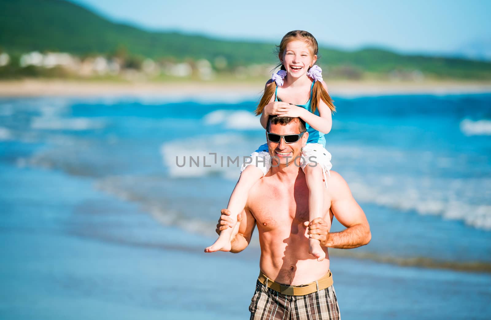 Happy father and his adorable little daughter on the beach