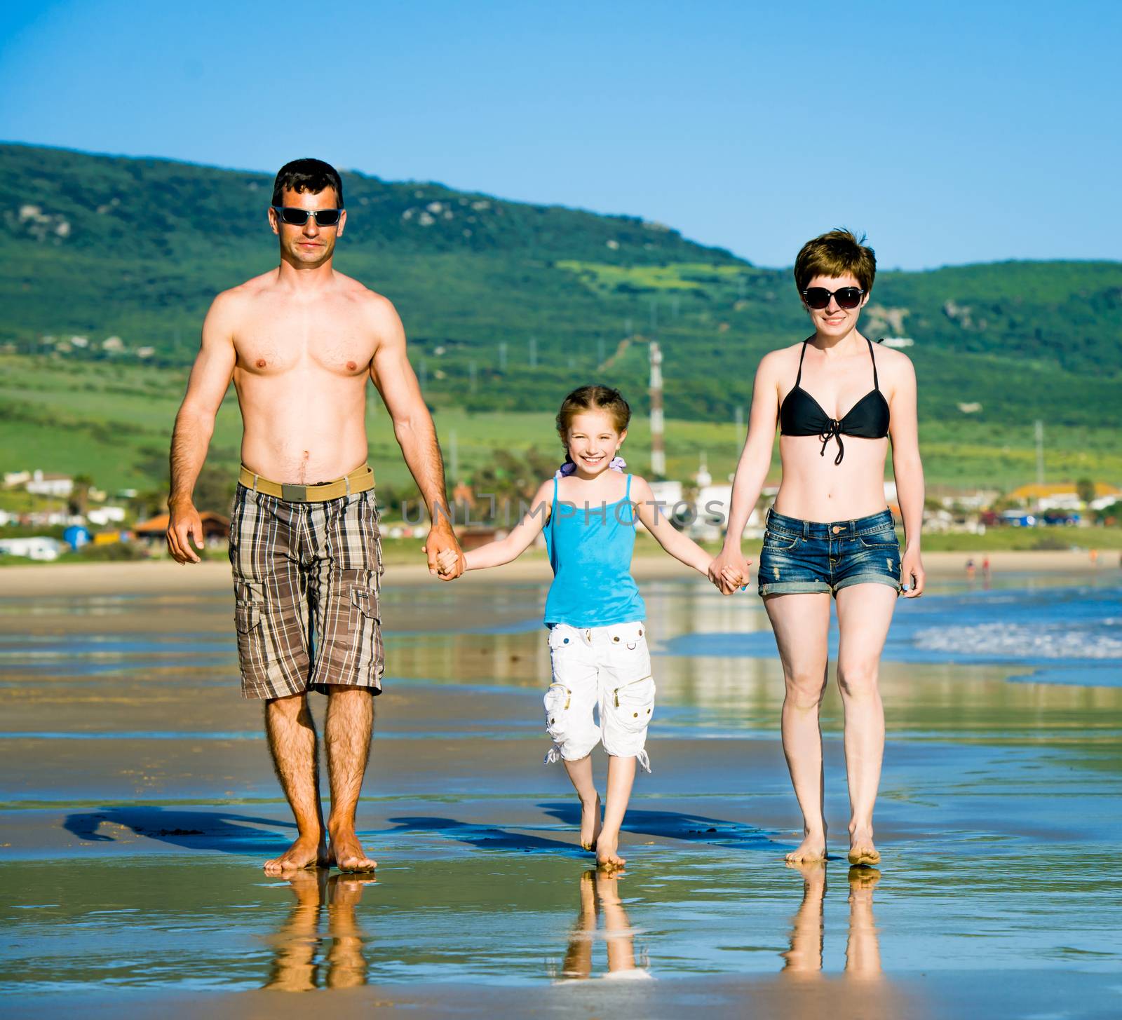 Family with daughter playing on the beach