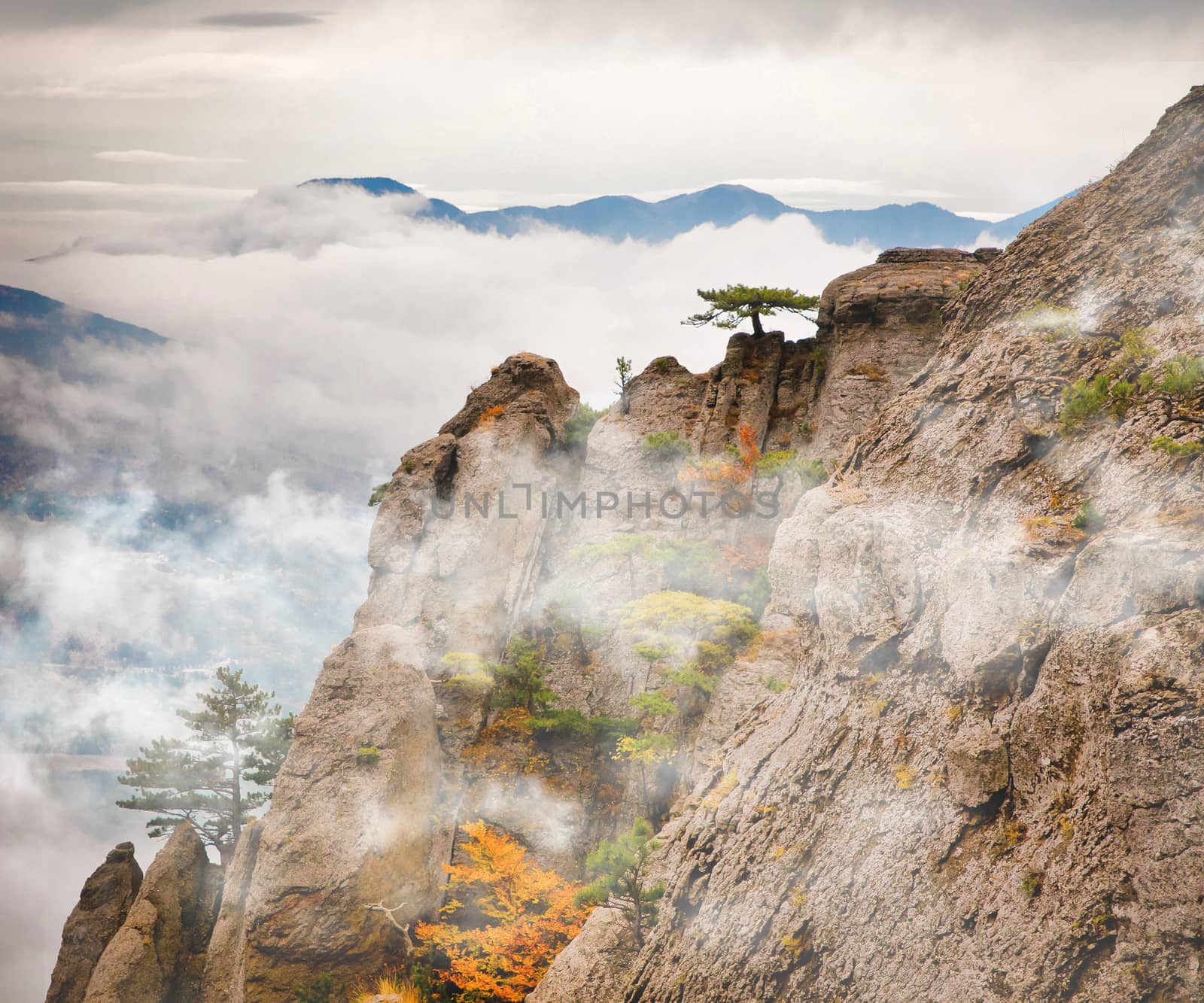 Beautiful view of rocks against the valley in fog