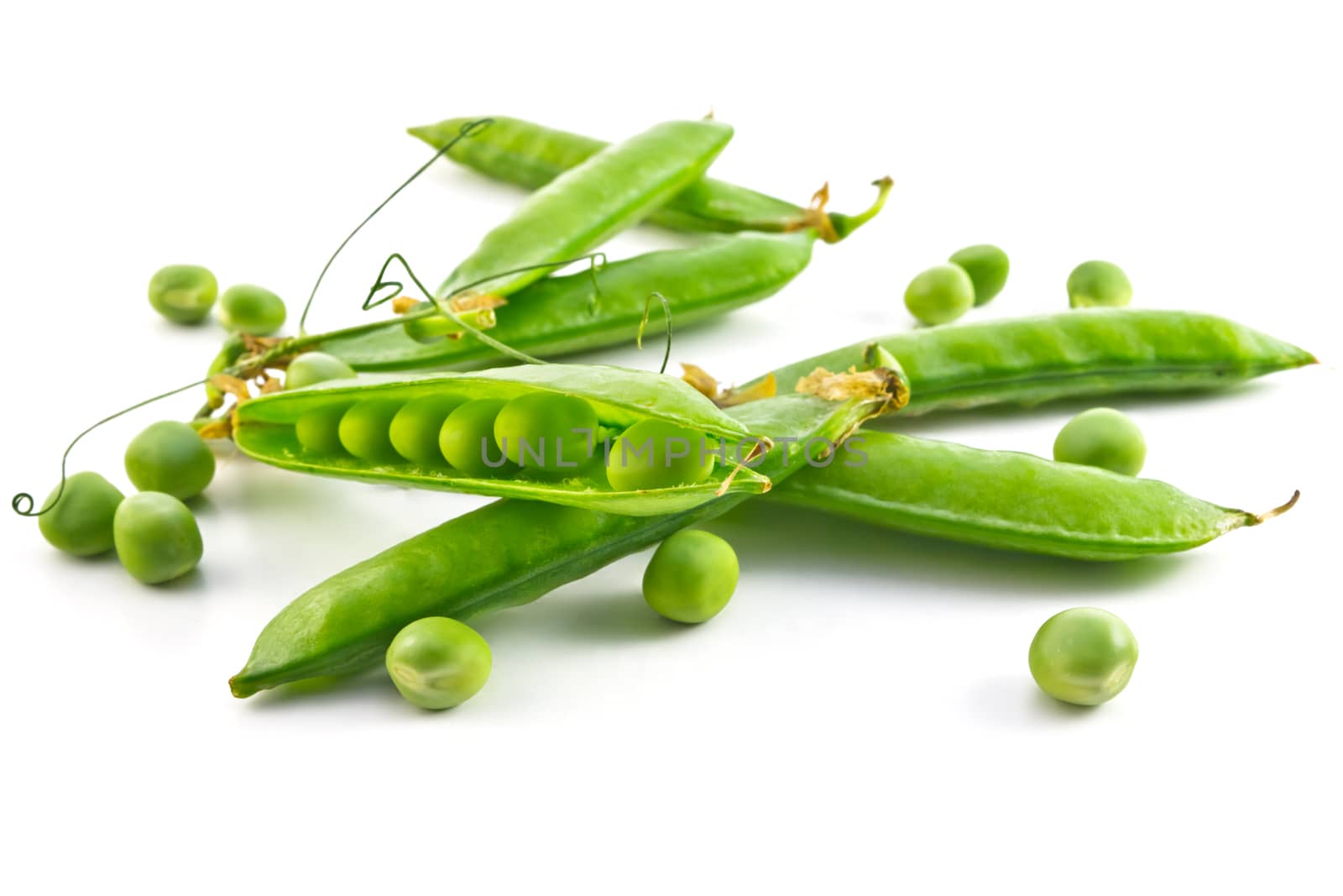 pods of green peas and some peas on a white background