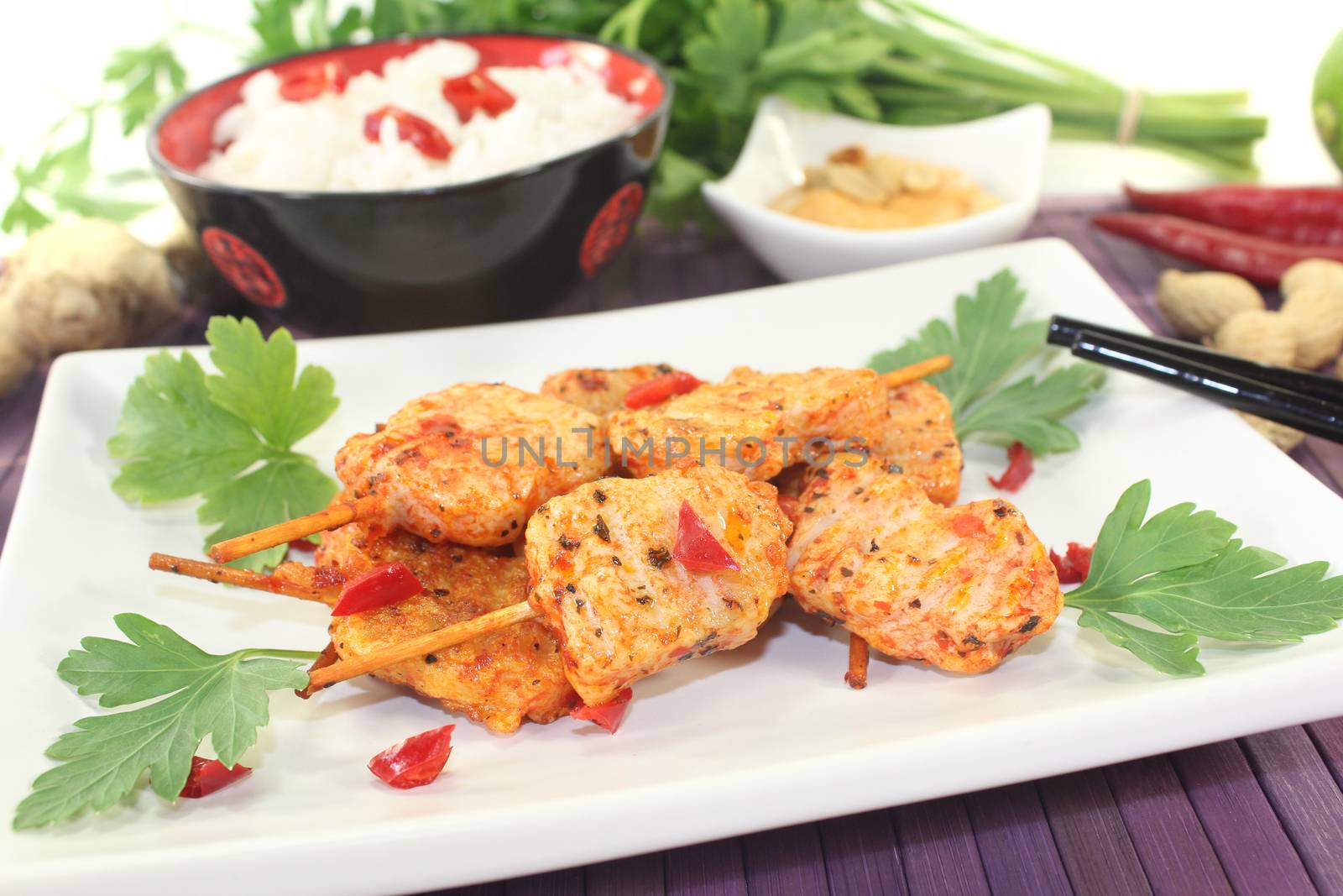 Asian satay skewers with peanut sauce and rice on a light background