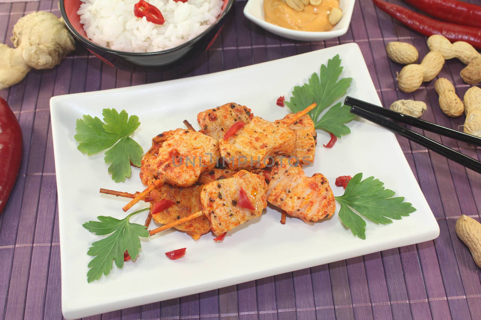 Asian satay skewers with rice, chili, peanut sauce and parsley