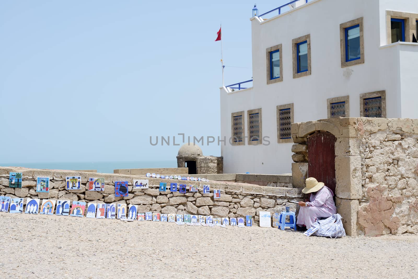 Artist in Essaouira in Morocco painting landscape scene in sunshine