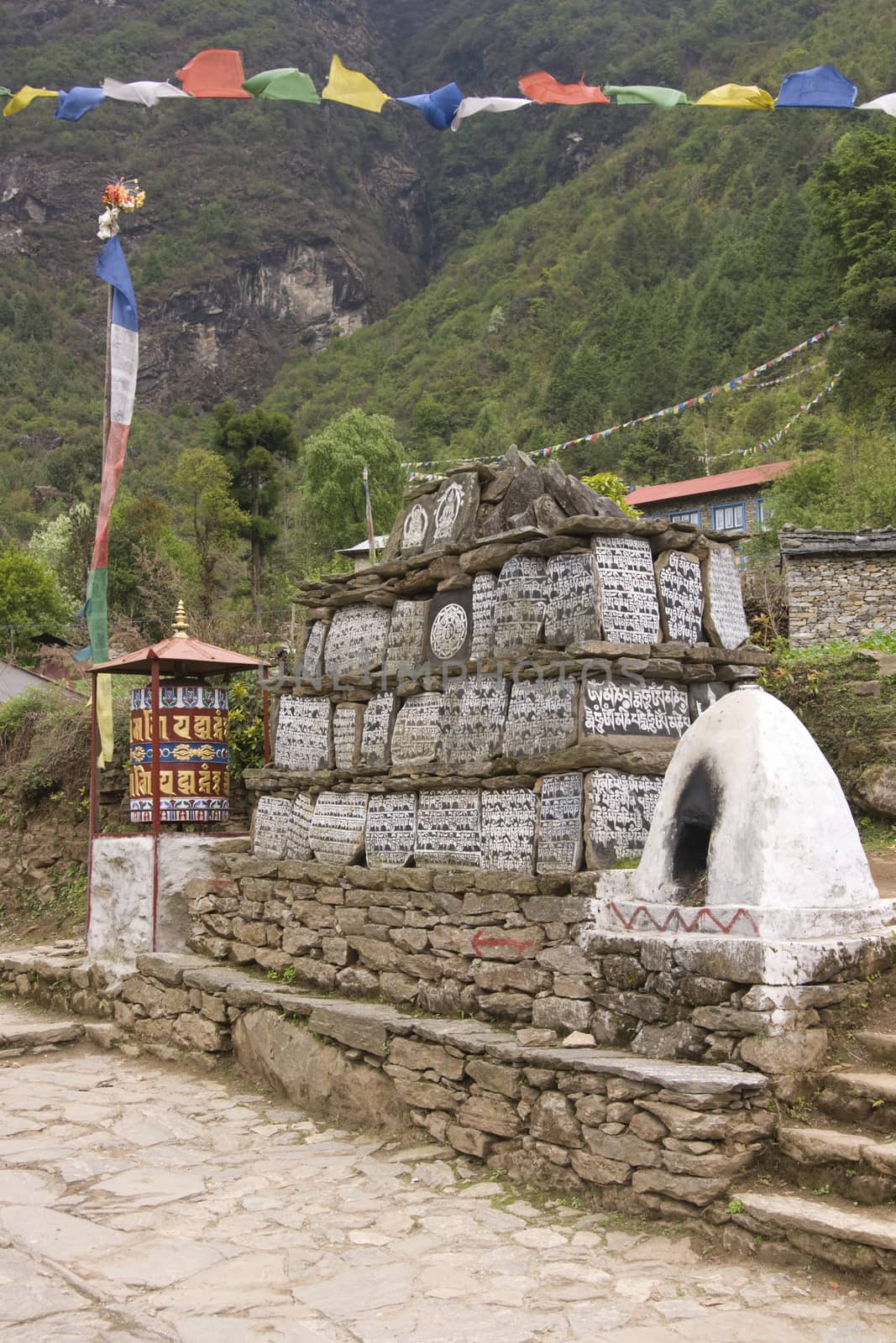 Buddhist Mani stones and prayer wheel along the trekking route to Everest Base camp in Nepal