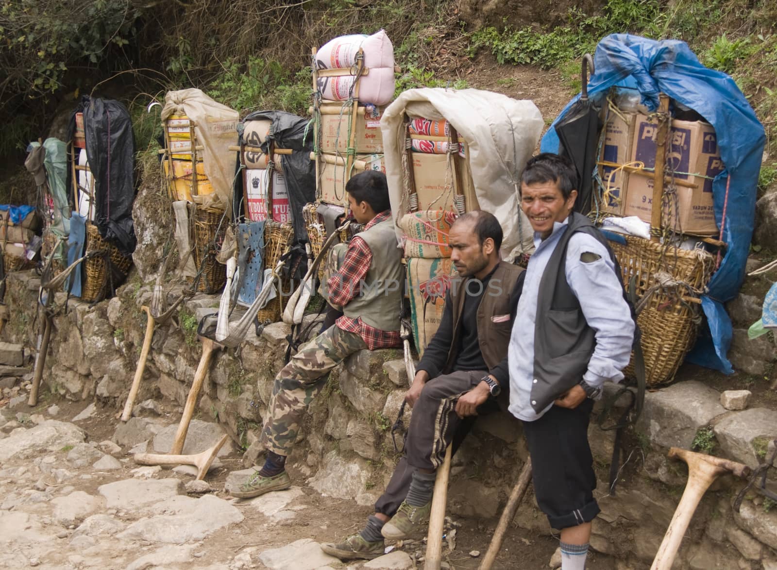 Porters resting next to the very heavy loads they are carrying in the Himalaya Mountains, Nepal