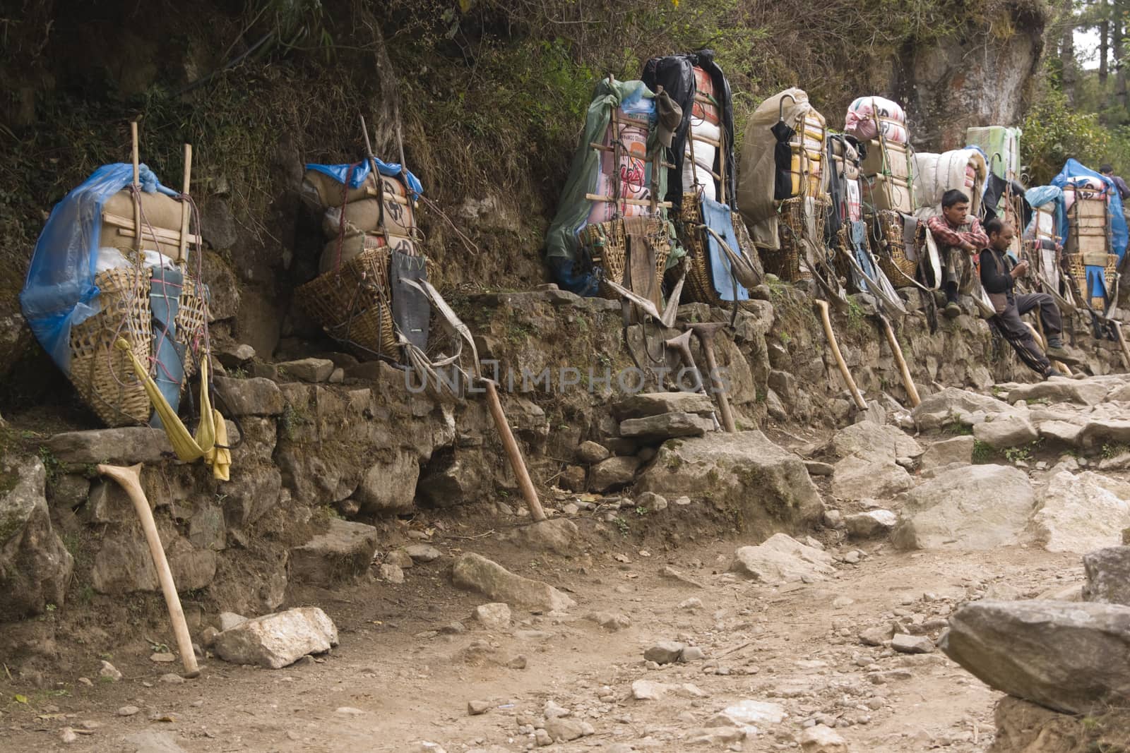 Porters resting next to the very heavy loads they are carrying in the Himalaya Mountains, Nepal