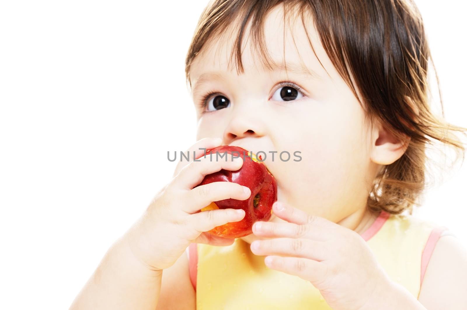 Little girl eating a fresh red apple