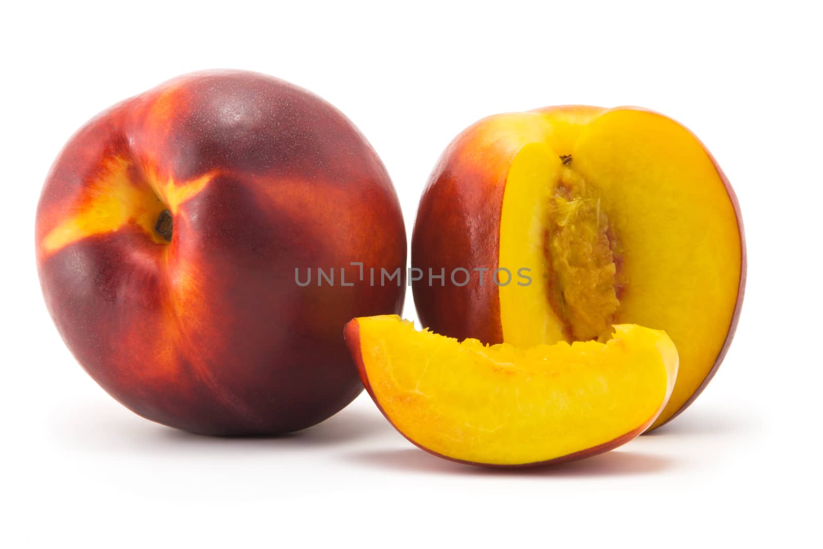 Two ripe juicy nectarine and cut portion on a white background