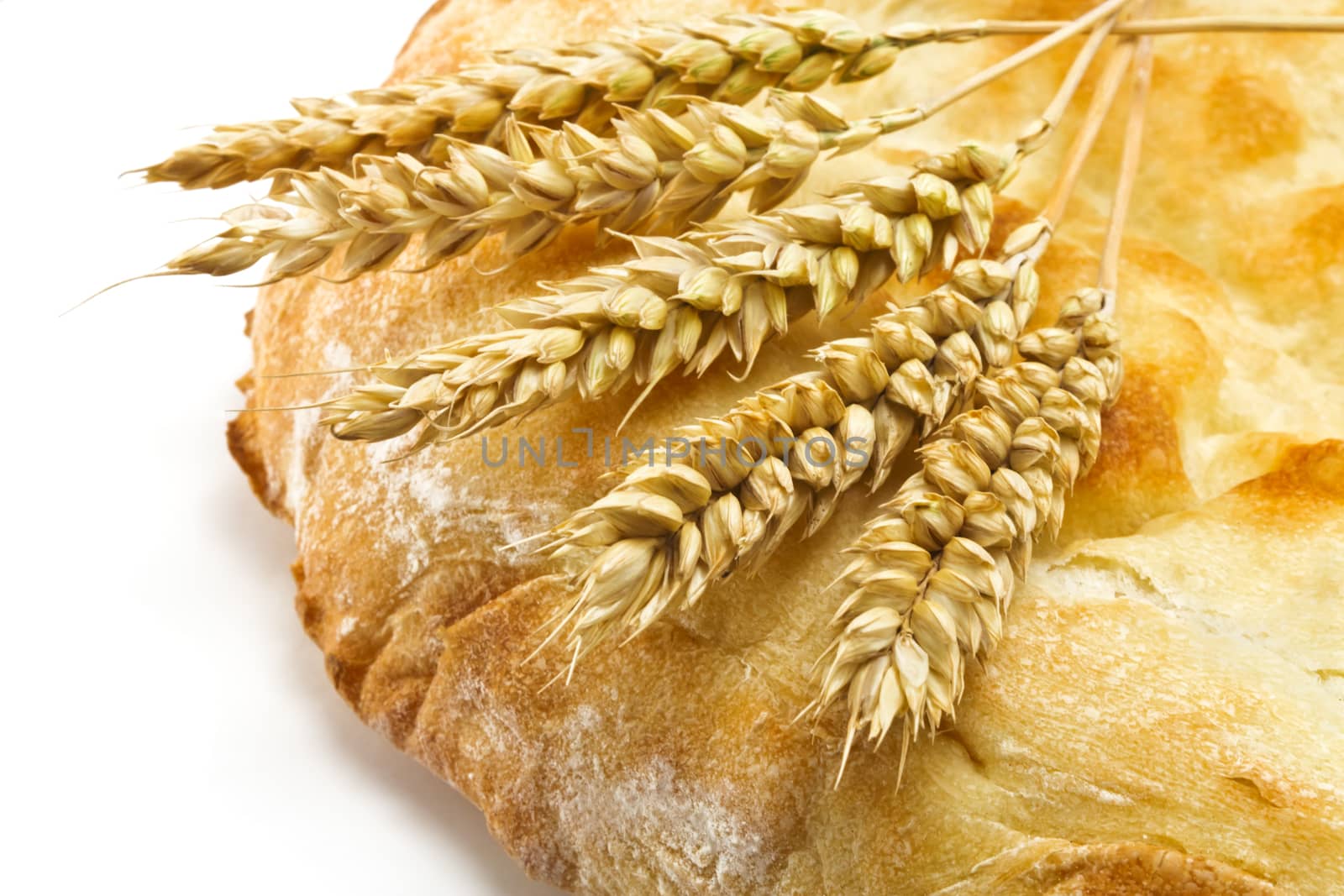 crispy pita bread and spikelets wheat on a white background