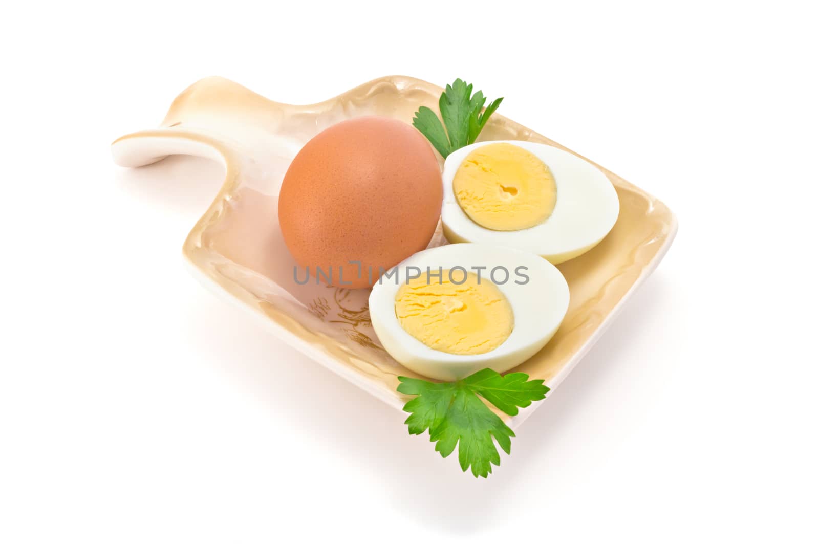 one egg, two halves of boiled eggs and parsley on the plate